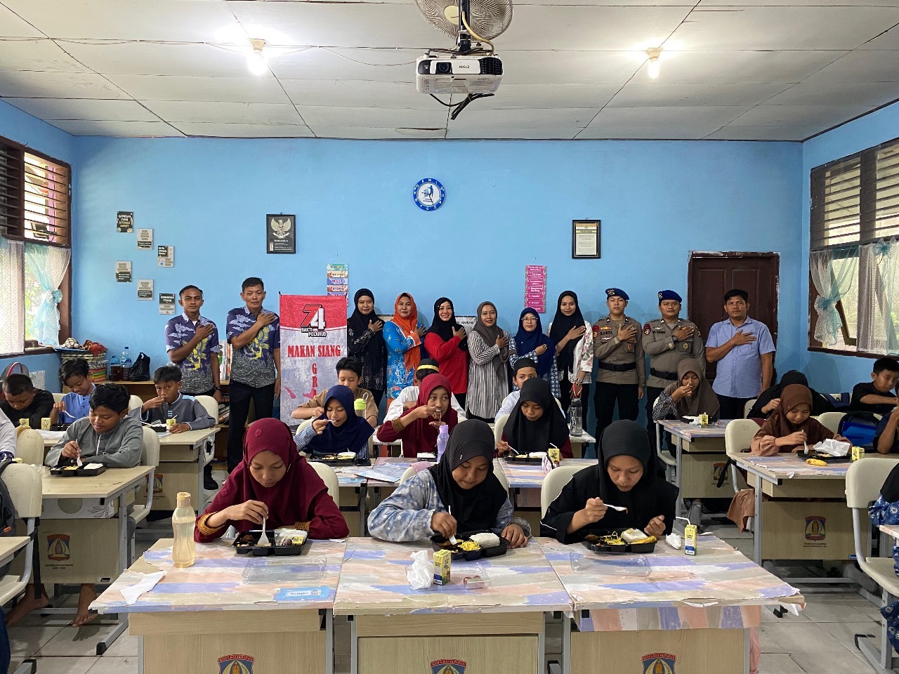 PEDULI GIZI: Personel Ditpolairud Polda Kaltim memembagikan makanan bergizi pada murid di dua SD wilayah Balikpapan Barat.