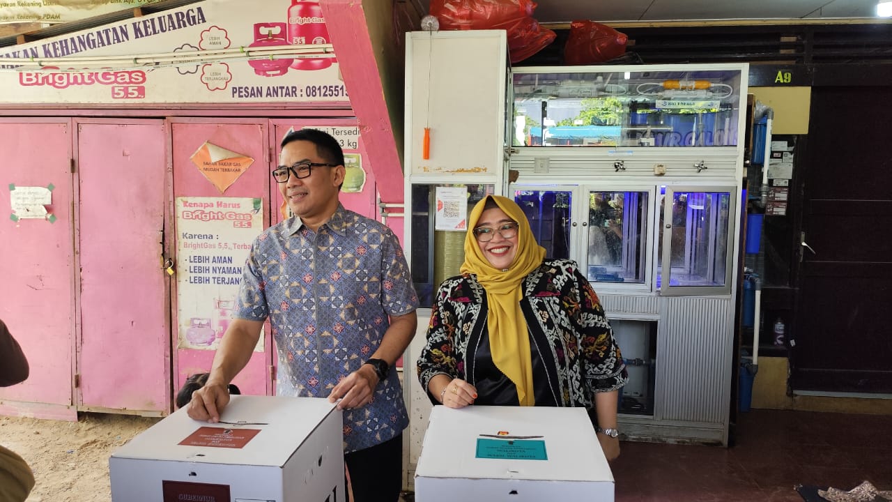 DENNY SAPUTRA/KP PILKADA: Andi Harun didampingi istrinya, Rinda Wahyuni, memasukkan surat surat saat menjalani proses pencoblosan di TPS 008, Kelurahan Sempaja Timur, Rabu (27/11).