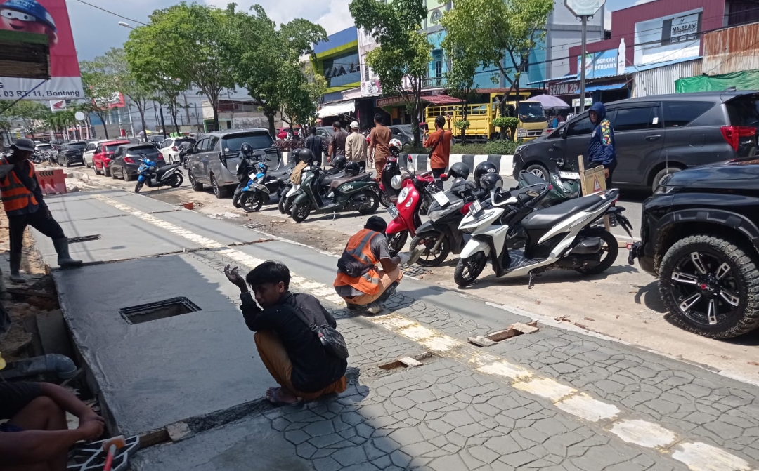KEBUT: Kontraktor pengerjaan perbaikan trotoar di Jalan Ahmad Yani memerintahkan pekerja bekerja dari pagi hingga malam untuk menyelesaikan proyek ini.