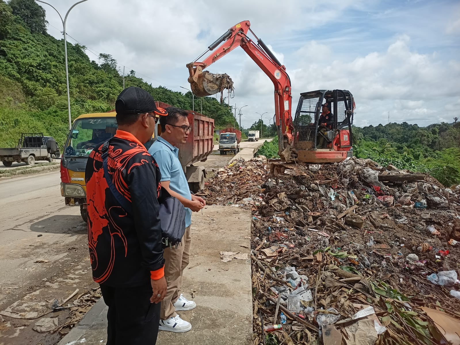 PANTAU KONDISI: Saipul Anuar (kedua kiri) memantau pembersihan tumpukan sampah oleh tim BPBD dan DLH di Jalan Nusyirwan Ismail Kelurahan Lok Bahu Kecamatan Sungai Kunjang, Jumat (17/1). (FOTO: IST)