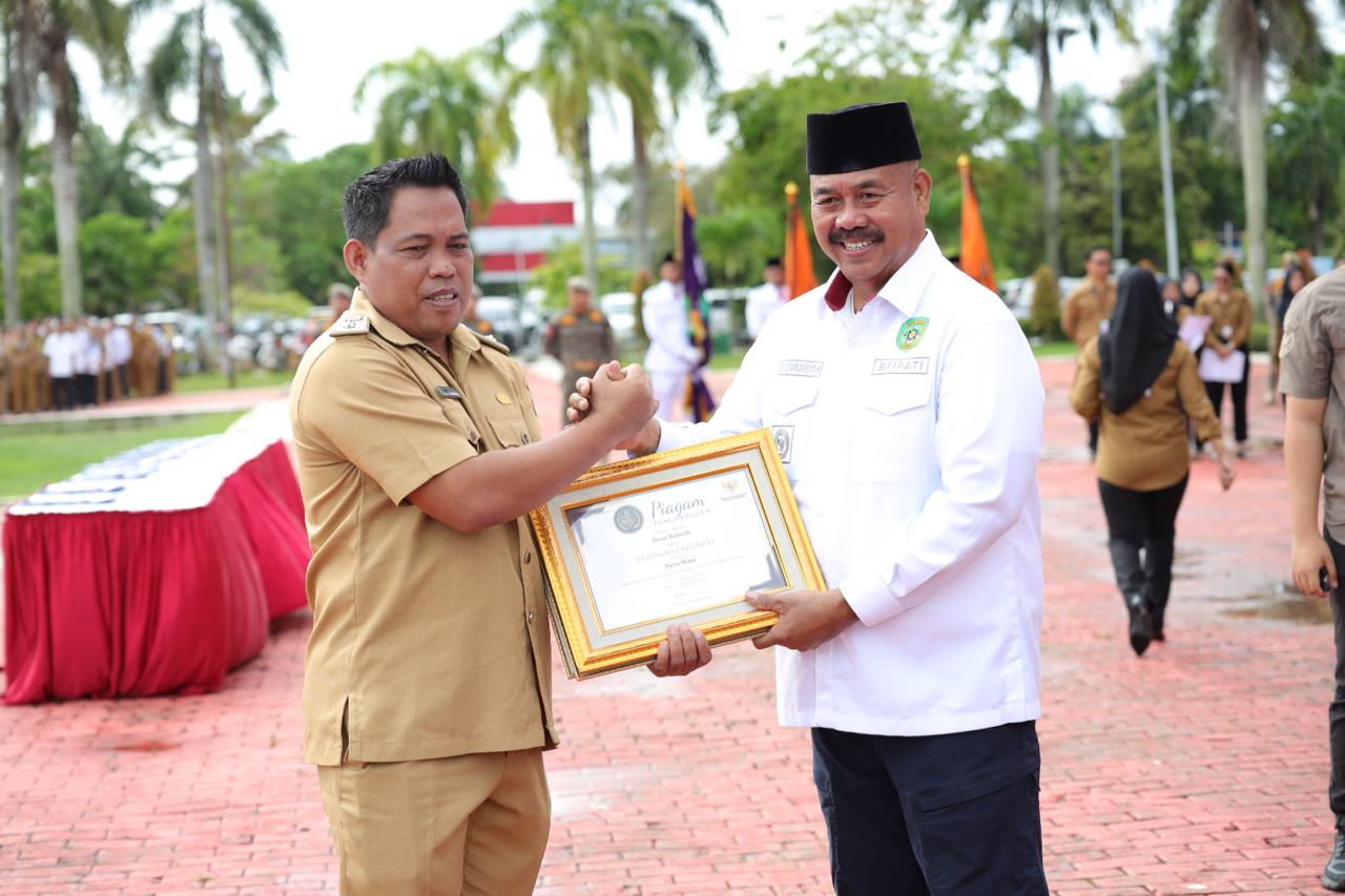 KEBERHASILAN: Kepala Desa Batuah Abdul Rasyid (kiri) menerima panji-panji keberhasilan pembangunan yang diserahkan Bupati Kukar Edi Damansyah.