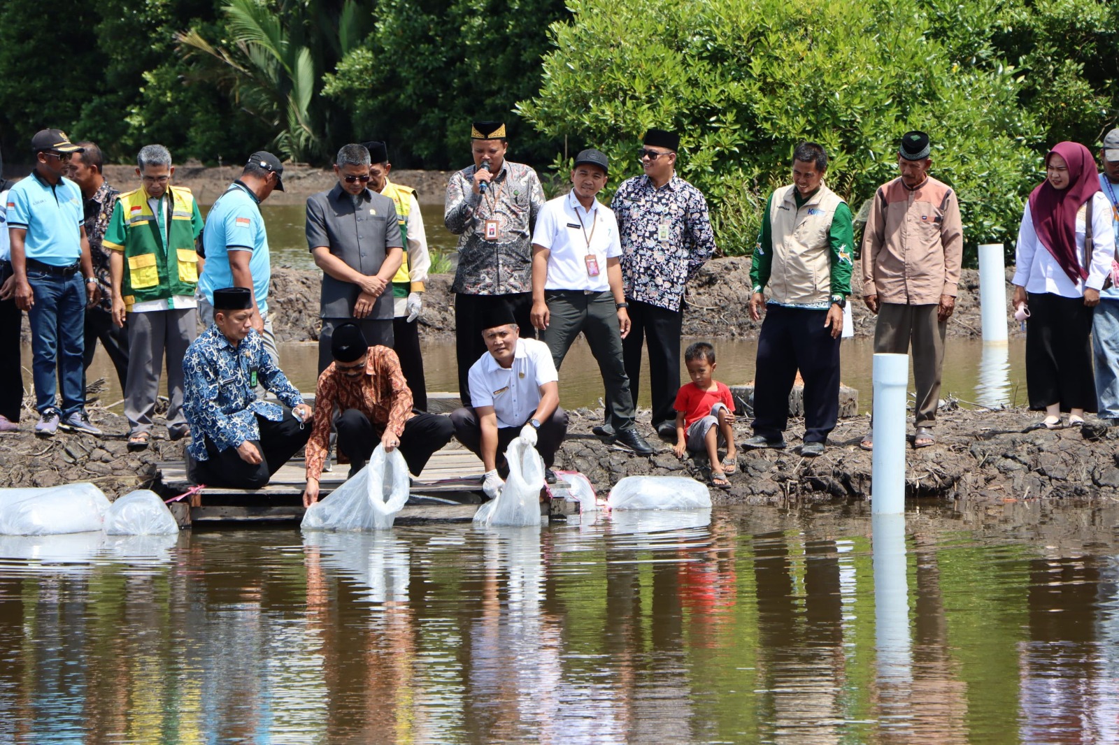 TEBAR: Kepala Bagian Kesejahteraan Rakyat, Setkab PPU, Muhammad Daud (baju putih) saat menebar bibit ikan pada Wisata Pemancingan Kampung Zakat, PPU. (FOTO: IST)