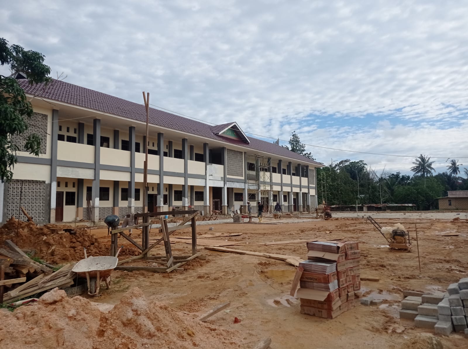 Kontraktor masih melakukan pemasangan keramik dan paving block di SD 002 Bontang Barat kendati sebelumnya menargetkan rampung di akhir Januari. (ADIEL KUNDHARA/KP)