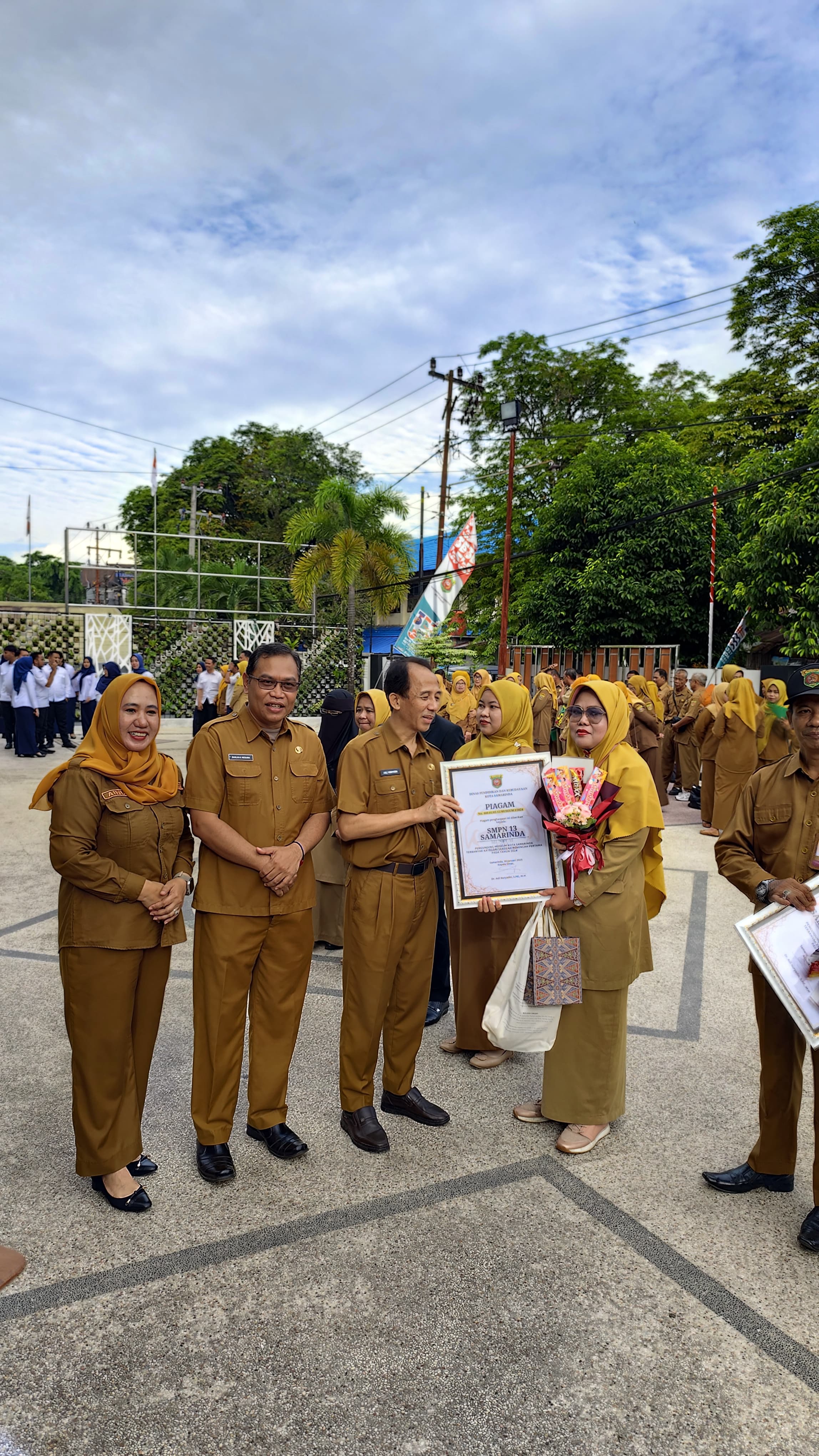 PENGHARGAAN: Plt Kepala SMP 13 Samarinda Hj Dini Indriani (kanan) menerima penghargaan dari Kepala Disdikbud Kota Samarinda Asli Nuryadin pada, Senin (3/2).