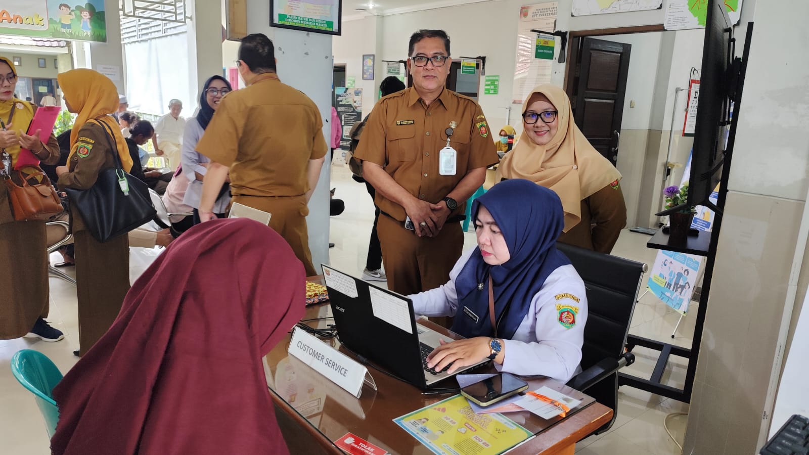 TAHAPAN: Dr Ismid Kusasih didampingi Kepala Puskesmas Air Putih Drg Zheditya Ayu Syawalia (kanan) memastikan pelaksanaan pendaftaran pasien berjalan lancar dalam kegiatan Kick Off CKG secara nasional.