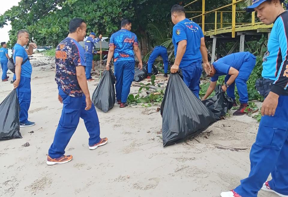 BERSIH PANTAI: Masyarakat dan personel Ditpolairud Polda Kaltim memungut sampah sekitar pesisir pantai Pelabuhan Semayang.