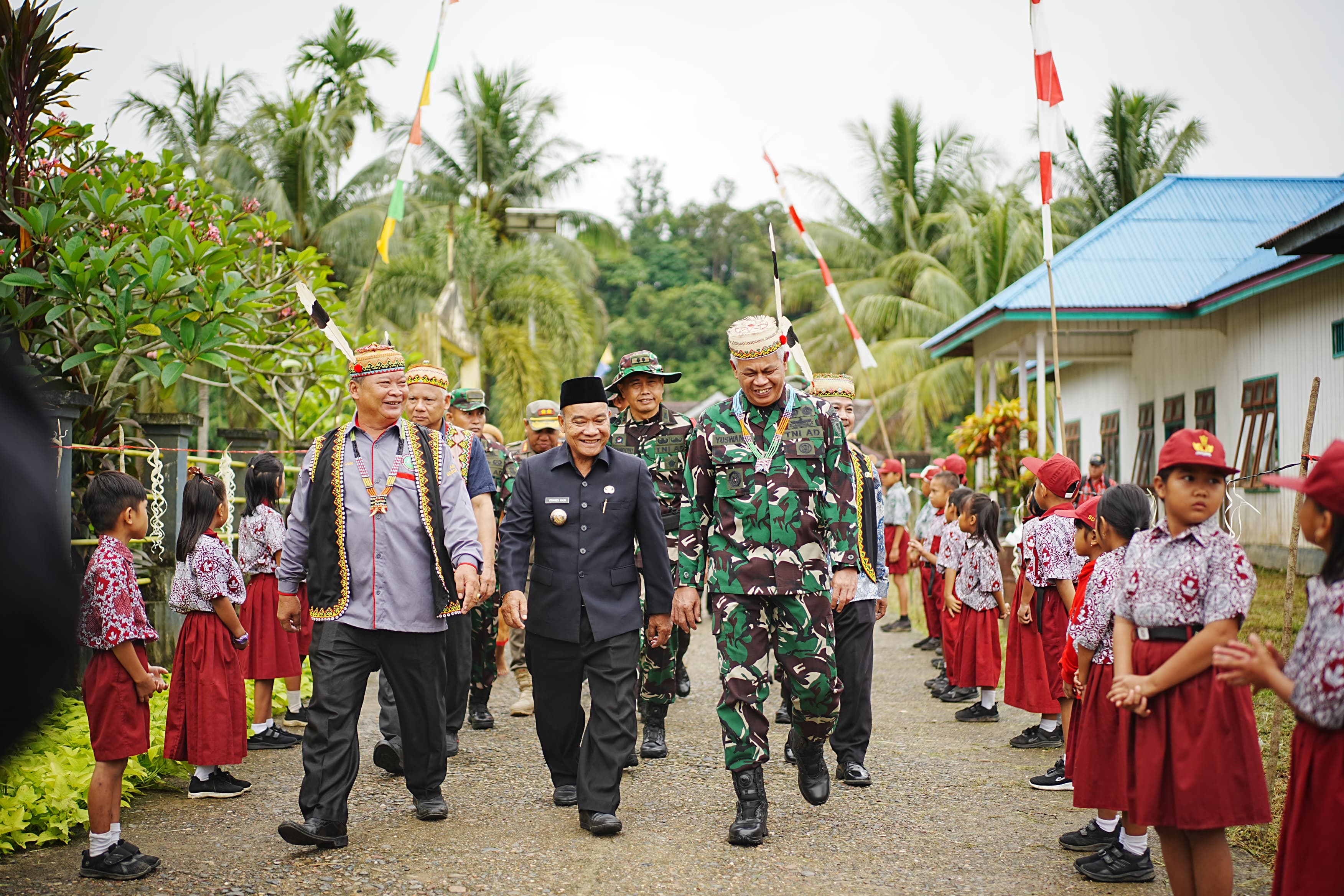 DISAMBUT: Kapok Sahli Pangdam VI /Mulawarman Brigjen TNI Drs Yuswandi didampingi Wakil Bupati Mahulu Yohanes Avun disambut anak sekolah setiba di Kampung Laham, Kamis (20/3).