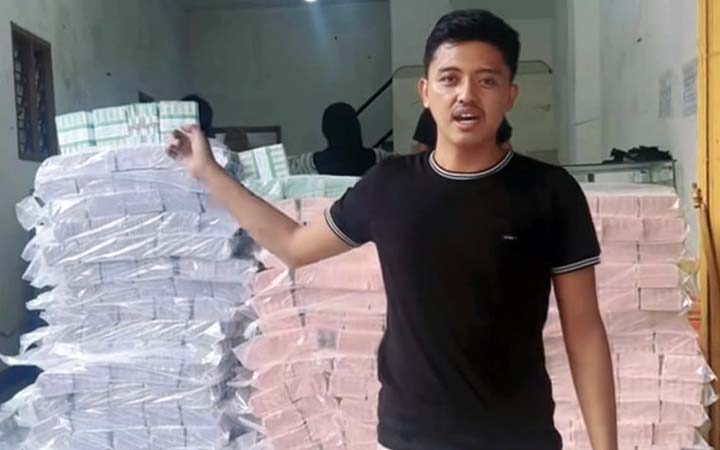Tangkapan layar seorang pria menunjukkan tumpukan uang baru di ruko Bangil, Kabupaten Pasuruan.