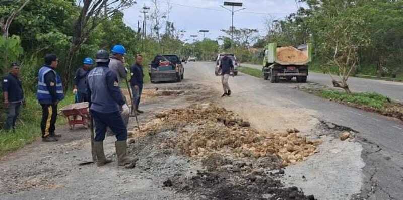 DITAMBAL: Lubang besar di Jalan M Roem, Bontang Lestari diisi dengan material untuk mengurangi potensi kecelakaan lalu lintas.