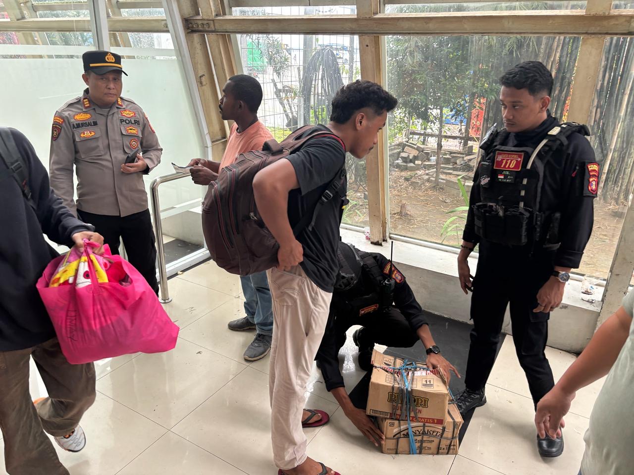 Petugas melakukan pemeriksaan barang bawaan penumpang yang baru turun dari kapal.