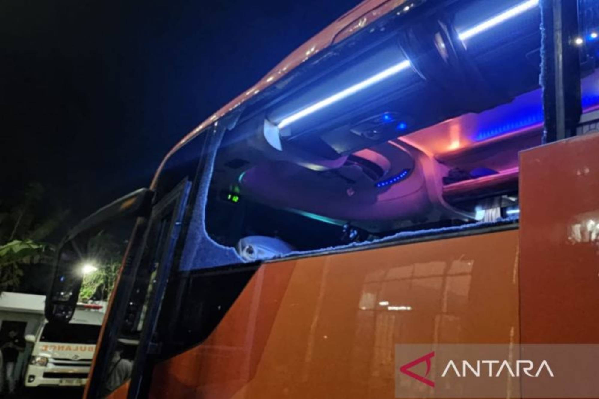 Kondisi kaca samping bagian depan bus yang ditumpangi Persik Kediri pecah setelah dilempar oleh kelompok suporter di jalan raya depan Stadion Kanjuruhan.