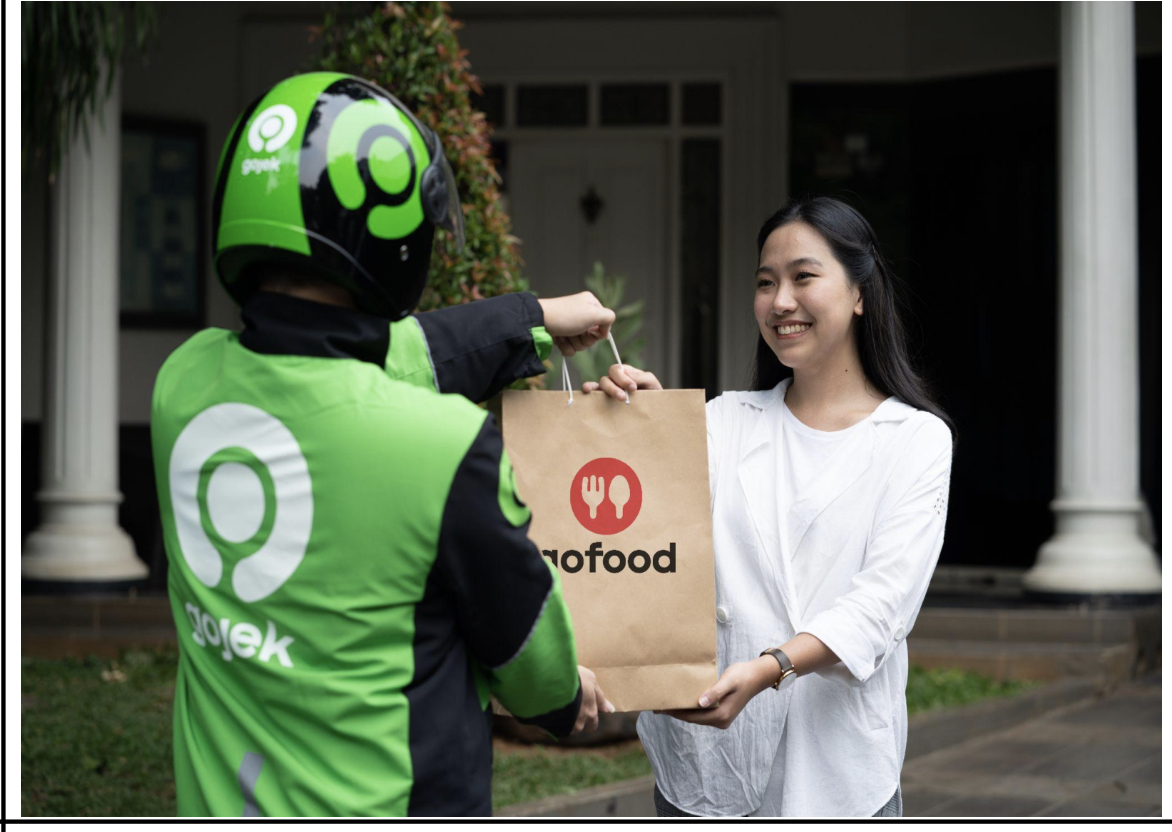 Driver Gojek saat mengantarkan makanan ke pelanggan.