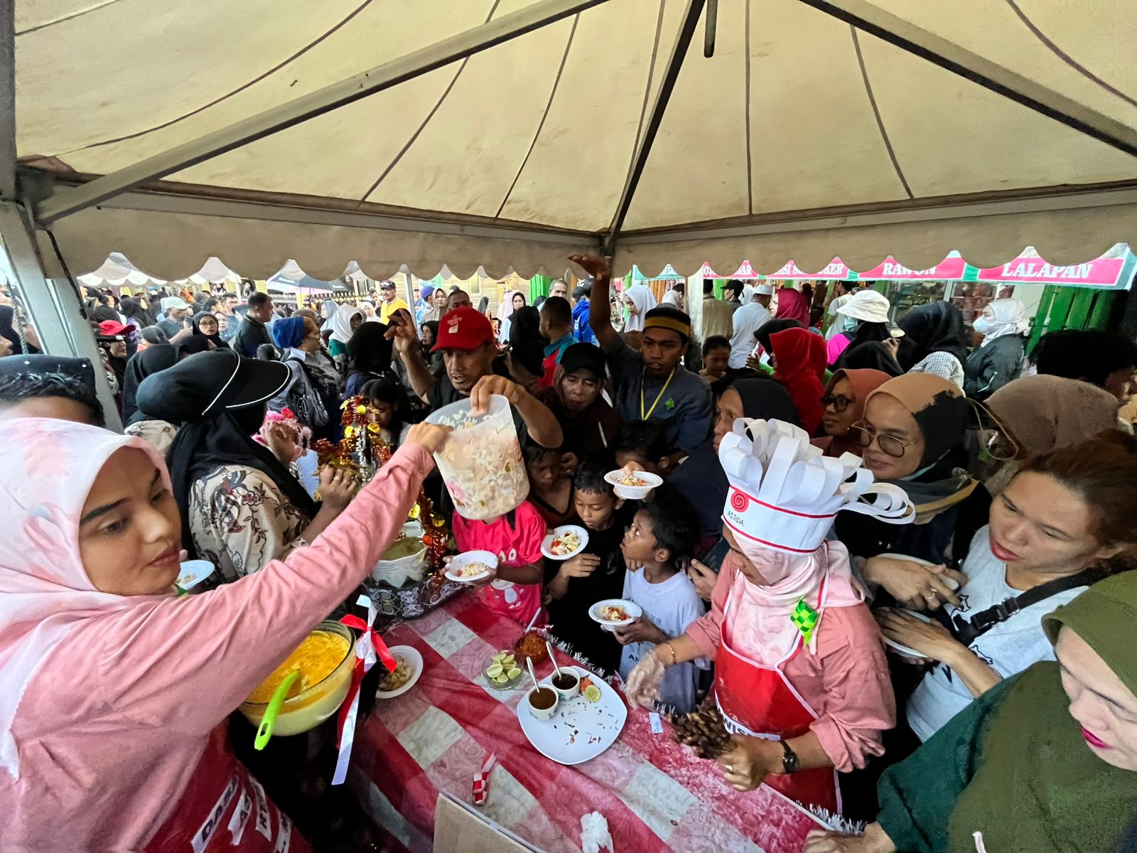KIAN RAMAI: Sejumlah pengunjung mengambil makanan gratis dalam penutupan Festival Kampung Ketupat di Kecamatan Samarinda Seberang, Minggu (18/5). (FOTO DENNY SAPUTRA/KP)