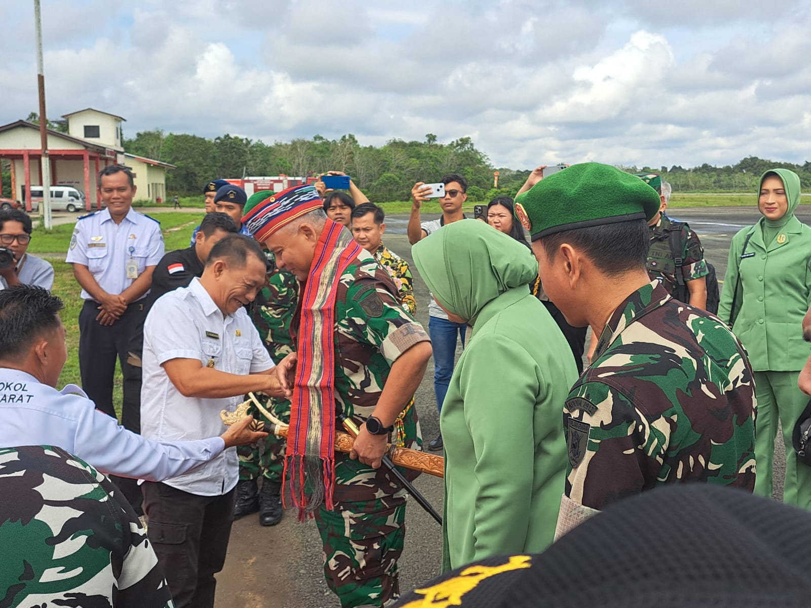 TRADISI: Mayjen Rudy Rachmat Nugraha saat disambut Nanang Adriani dengan tepung tawar dan pengalungan ulap doyo.