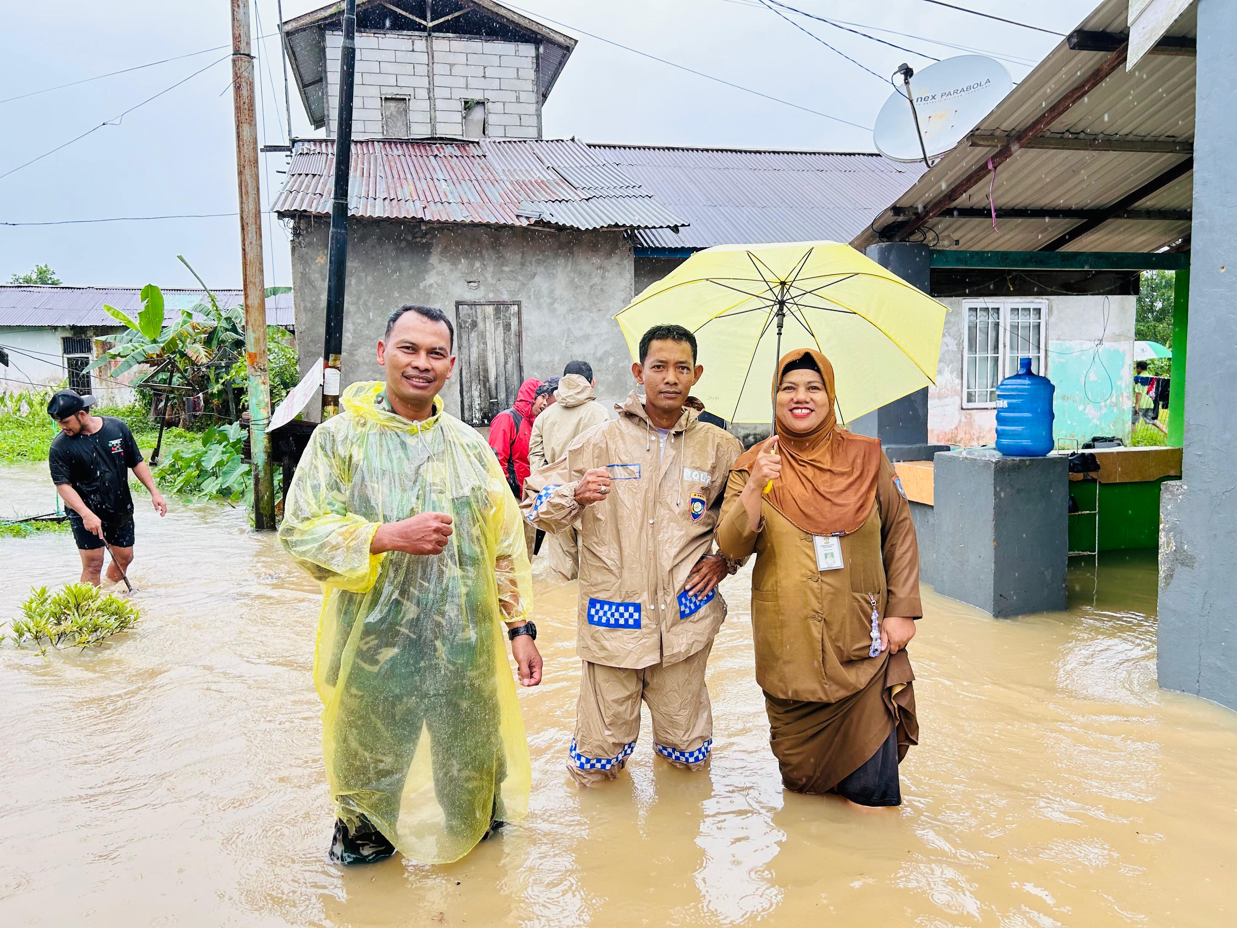KOMPAK: Sekretaris Kelurahan Lamaru Prijanti (kanan) saat monitoring banjir di RT 17 belakang Puskesmas bersama Bhabinkamtibmas dan Babinsa.  &nbsp;