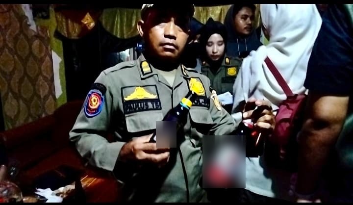 MIRAS: Petugas mengamankan puluhan botol minuman keras di lokalisasi Manggar Sari.