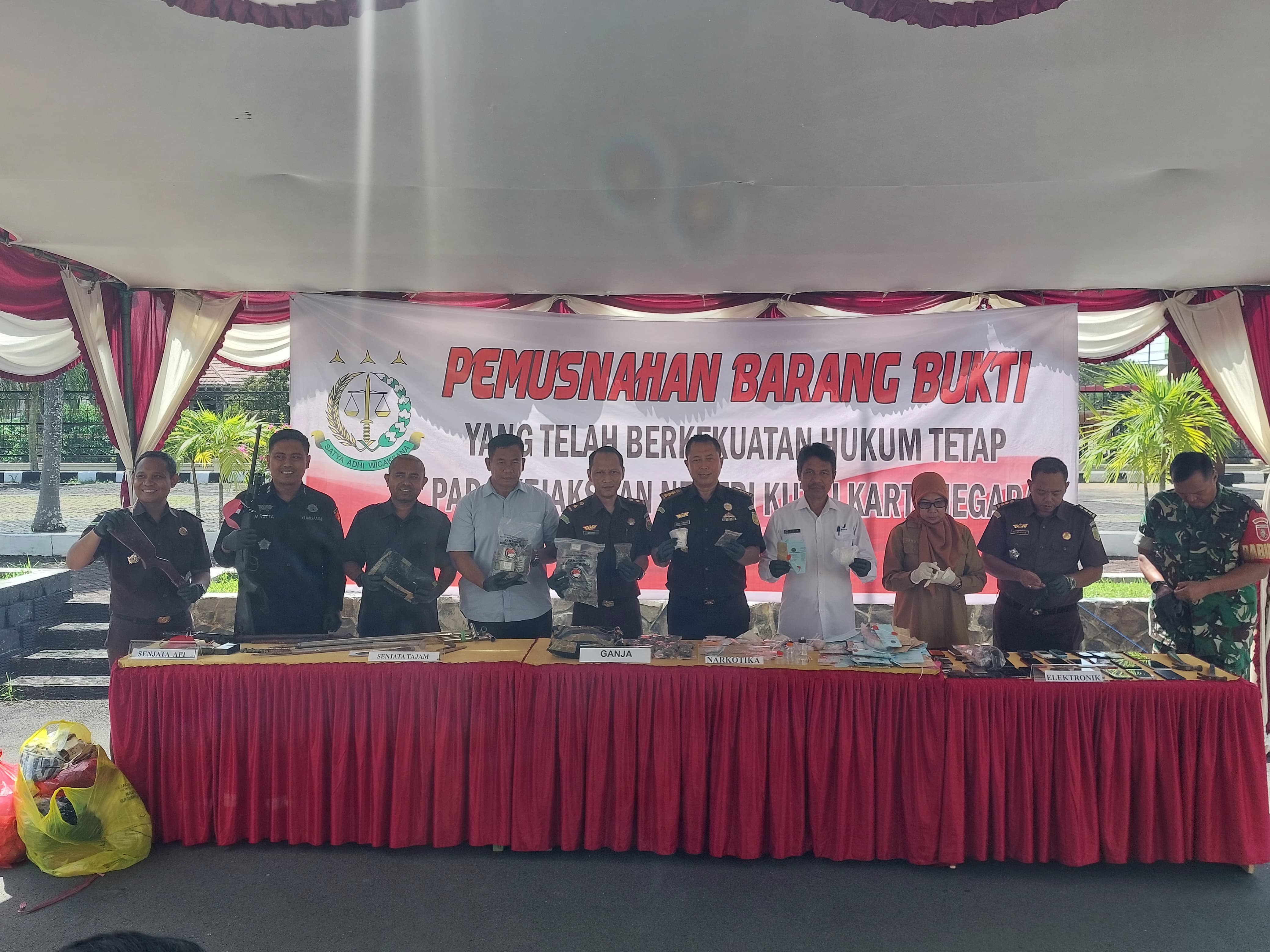 Plh Kepala Kejari Kukar bersama unsur forkopimda menunjukkan barang bukti sebelum dimusnahkan, terdiri dari sabu, ganja, senjata api rakitan, senjata tajam, dan barang elektronik. (RIFQI/KP)