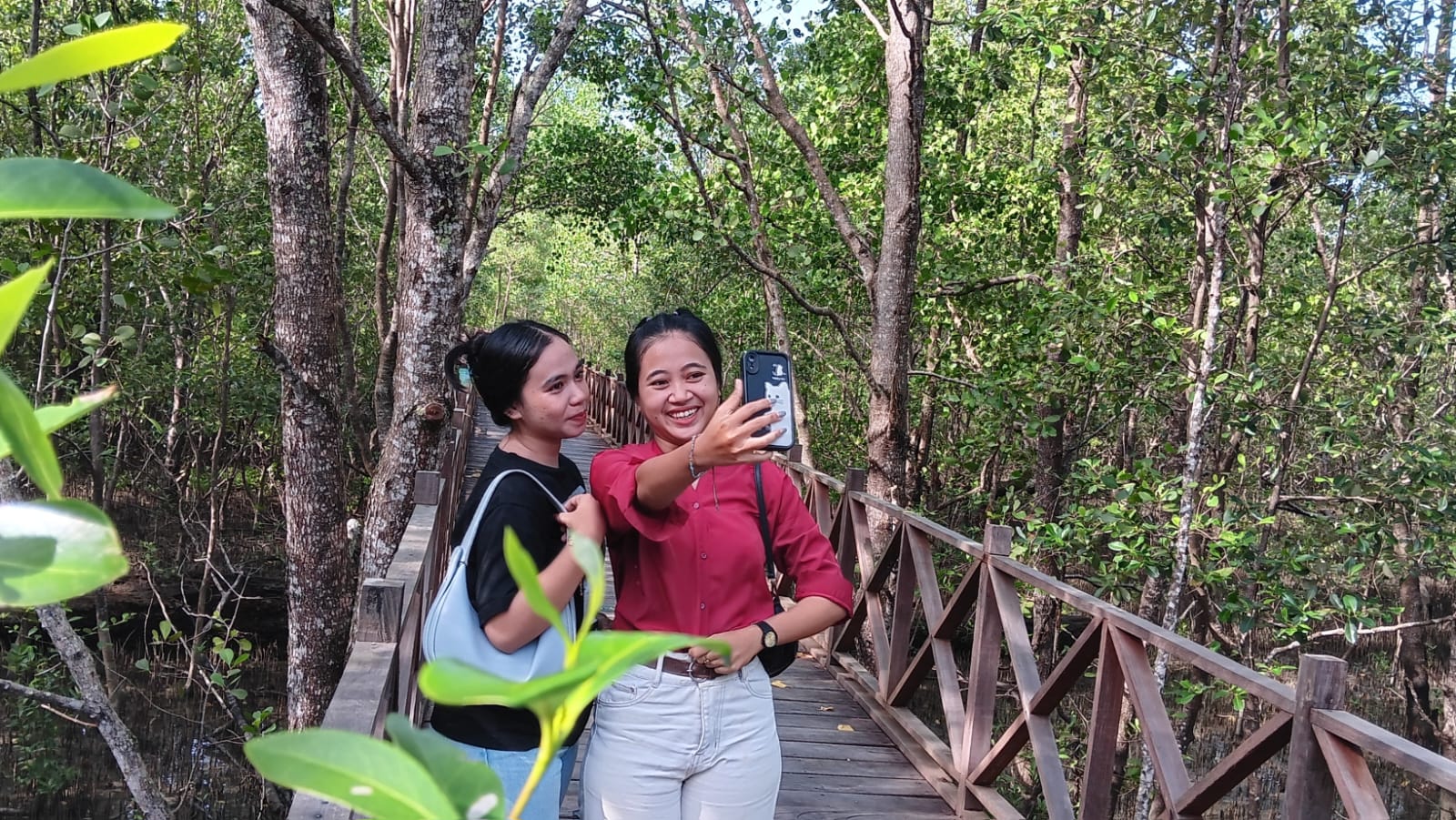 OBJEK WISATA: Maharani (baju merah) bersama Nia berswafoto di kawasan mangrove.  &nbsp;