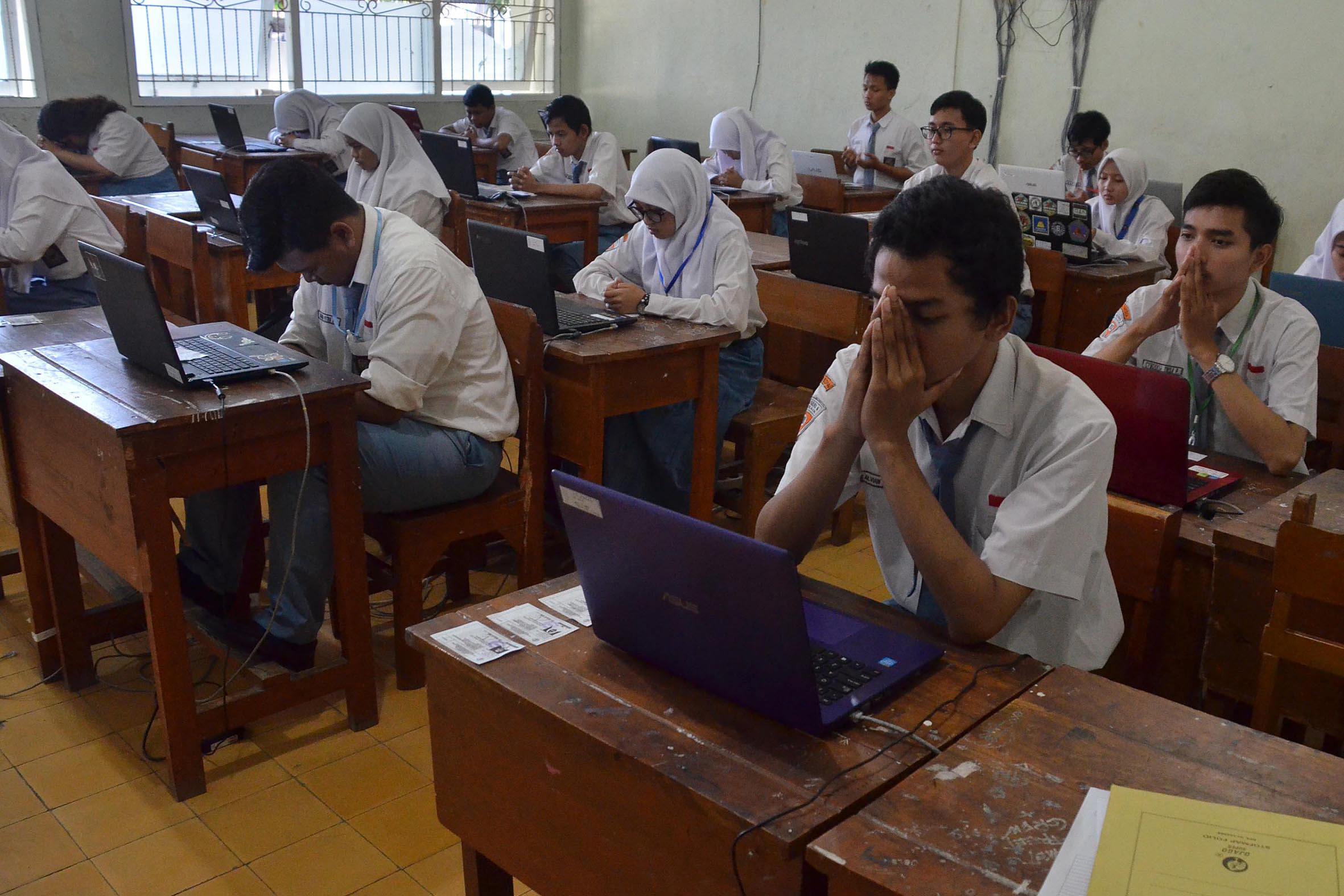 Ilustrasi siswa berdoa sebelum mengerjakan soal ujian nasional.