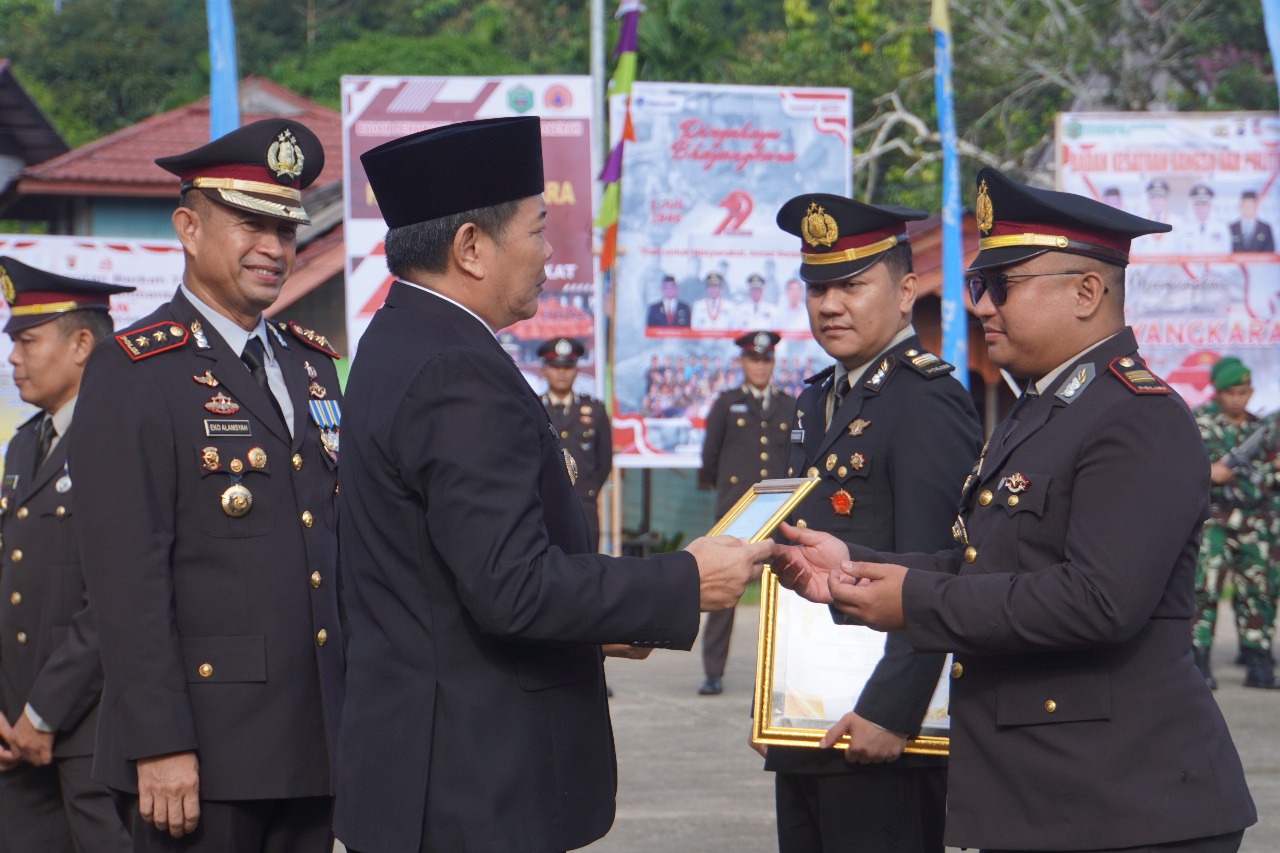 Bupati Bonifasius Belawan Geh memberikan penghargaan kepada para anggota Polres Mahulu pada perayaan  Hari Bhayangkara Ke-79 di Alun-alun Ujoh Bilang, Selasa (1/7/2025).