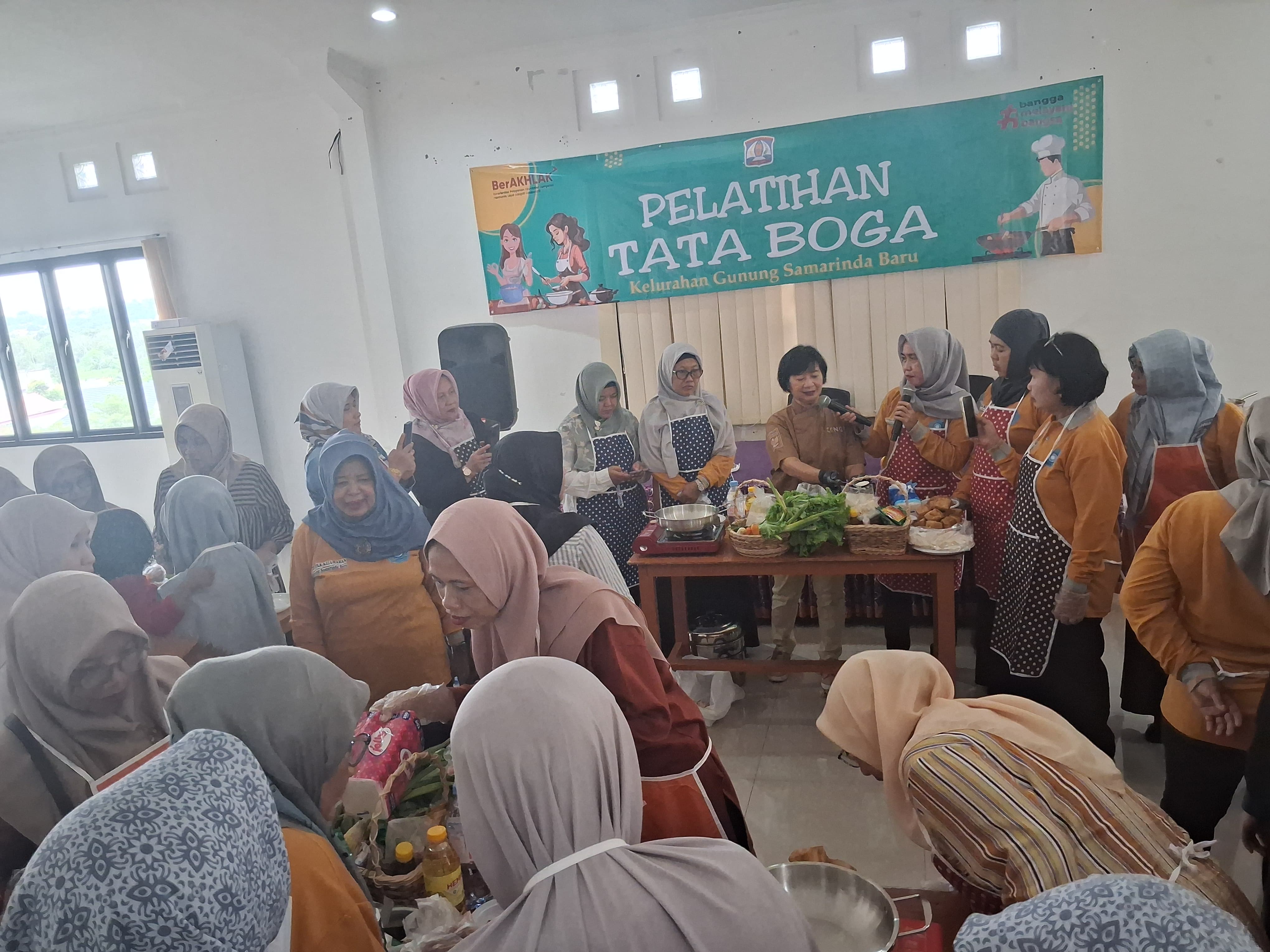 Lurah Gunung Samarinda Baru Kusuma Lestari mendampingi Chef Eeng, mempraktikkan cara mengolah makanan berbahan dasar ikan.