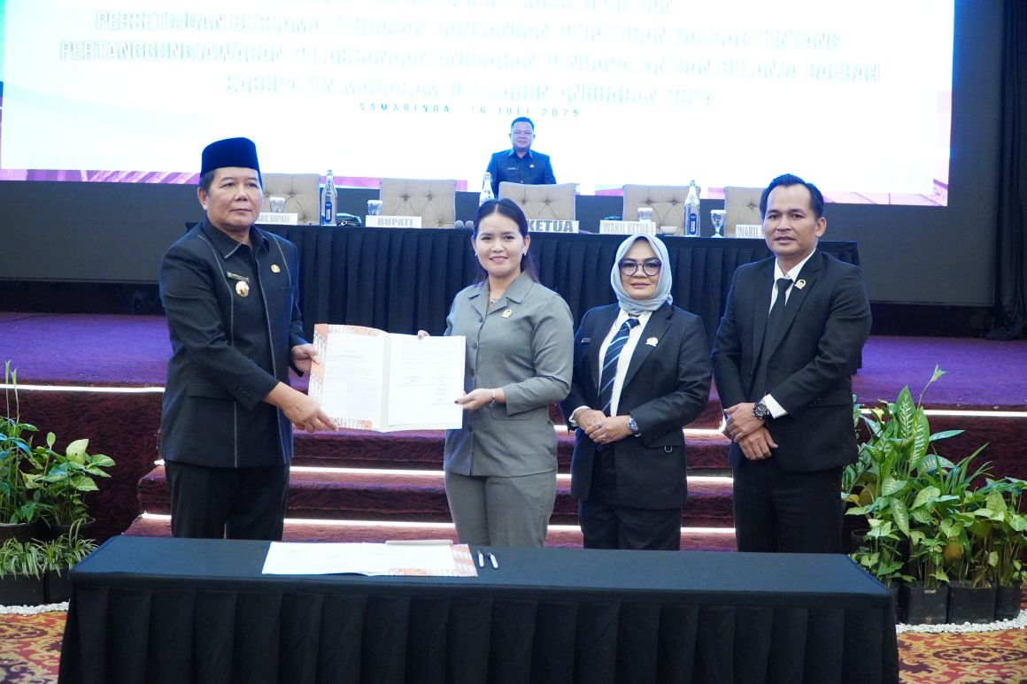 Bupati Mahulu, Bonifasius Belawan Geh (kiri) dan Ketua DPRD Mahulu Devung Paran menunjukkan Raperda Pertanggungjawaban APBD 2024 yang telah disetujui di Hotel Aston Samarinda, Selasa (16/7).