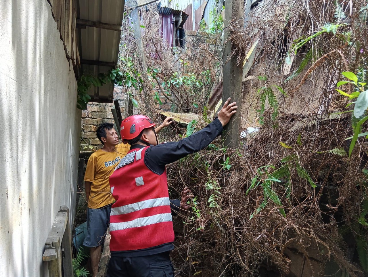 Petugas melakukan upaya bantuan di lokasi tanah longsor menimpa rumah warga kawasan Gunung Polisi, Balikpapan.