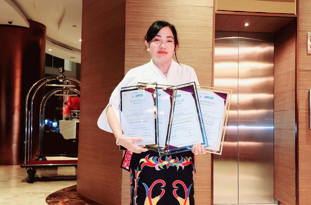 Megawati, External Relation & Security Manager PT TRUST, menunjukkan empat piagam penghargaan yang diraihnya dalam ajang Perempuan Berbakti 2025.