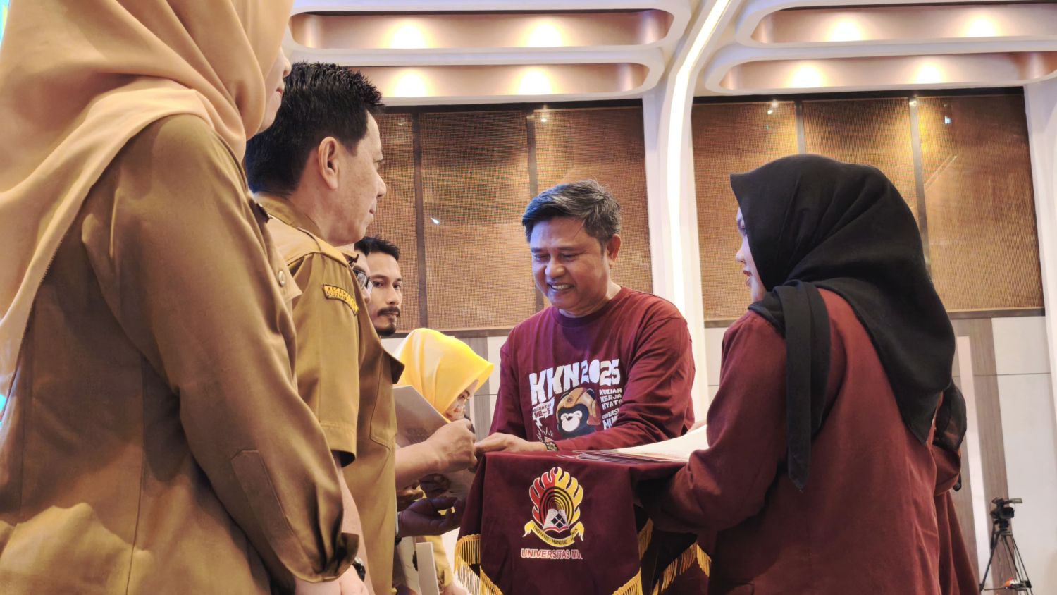 SINERGI: Rektor Universitas Mulia Prof. Dr. Ir. H. Muhammad Ahsin Rifai MSi, menyerahkan berita acara pelepasan KKN kepada perwakilan 21 lurah mitra Simbol sinergi perguruan tinggi dan pemerintah