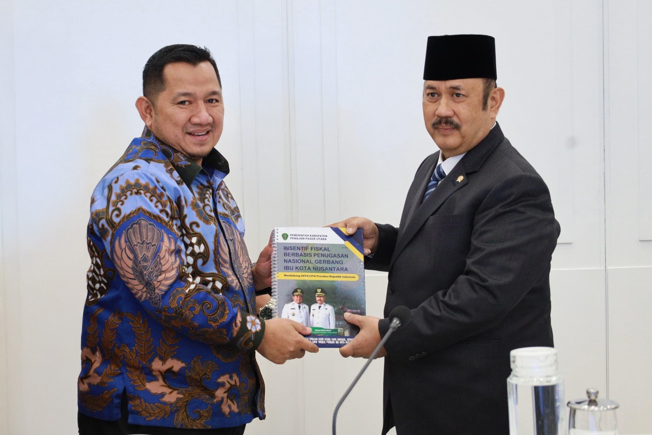 Mudyat Noor (kiri) memberikan buku terkait fiskal daerah kepada Rachmat Pambudy