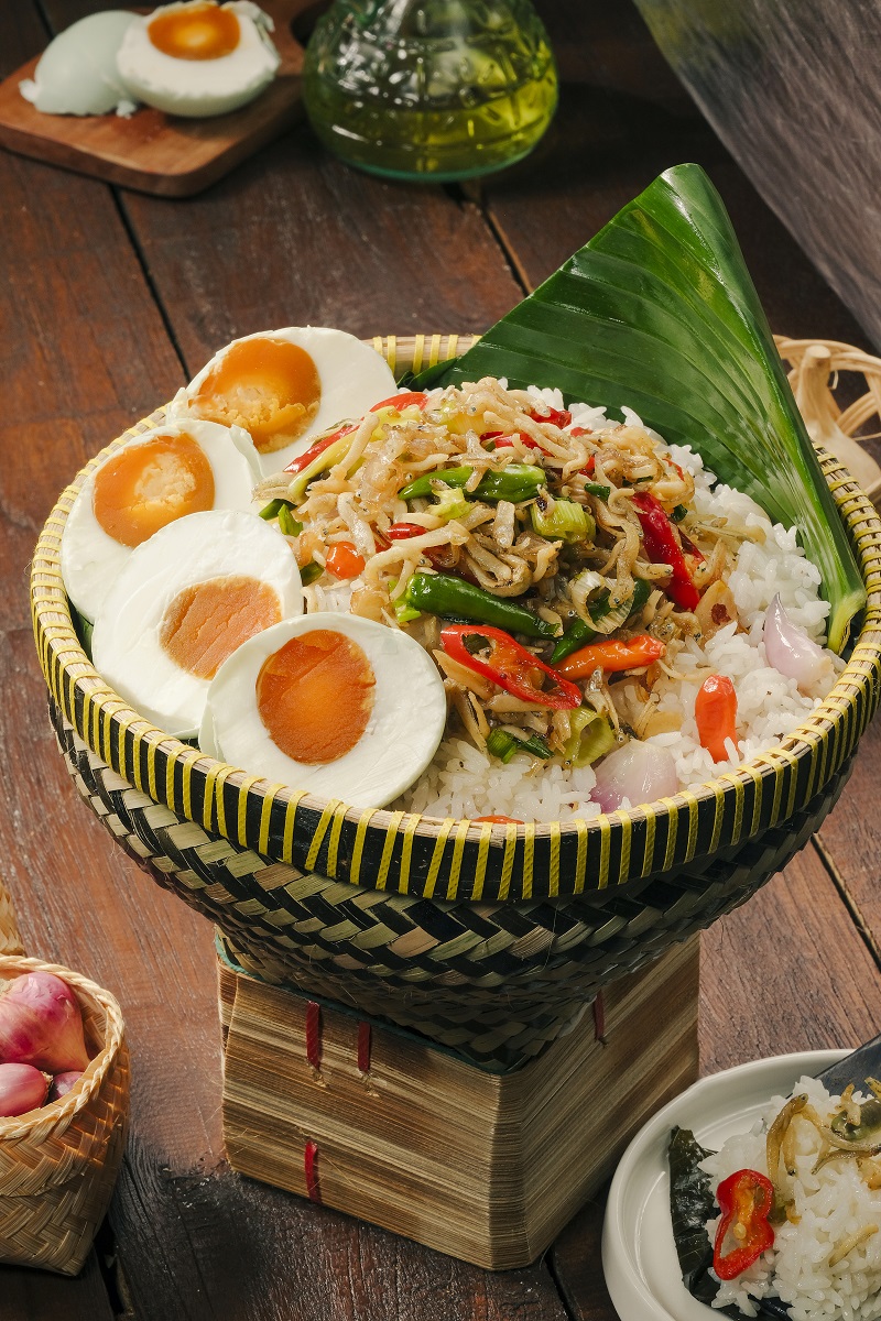 NASI LIWET TELUR ASIN: Nasi gurih khas liwet diuleni langsung dengan telur asin, disajikan bersama teri medan untuk tekstur renyah dan cita rasa asin gurih.