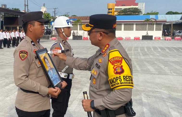 PTDH: Kapolresta Balikpapan Kombes Pol Anton Firmanto mencoret foto yang dibawa petugas provos dalam Upacara PTDH.