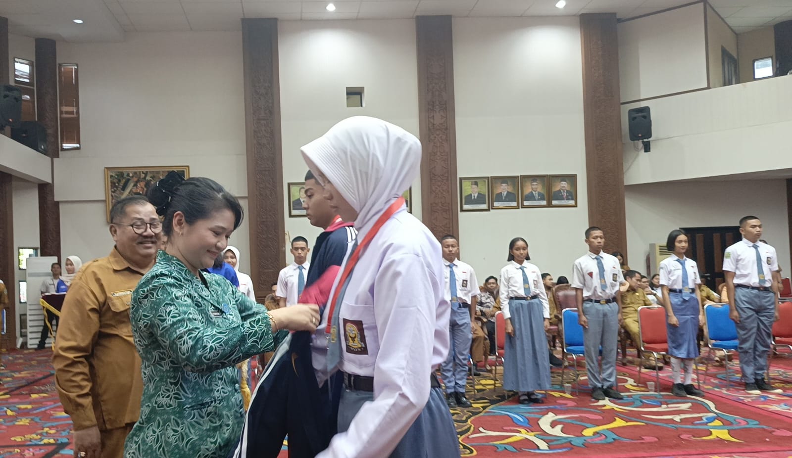 Sekda Kubar, Ayonius (belakang kiri) dan Ketua TP PKK Kubar, Ny Maria Christina  Mozes Edwin (baju batik) saat sematkan tanda peserta dan jaket calon Paskibraka secara  simbolis.