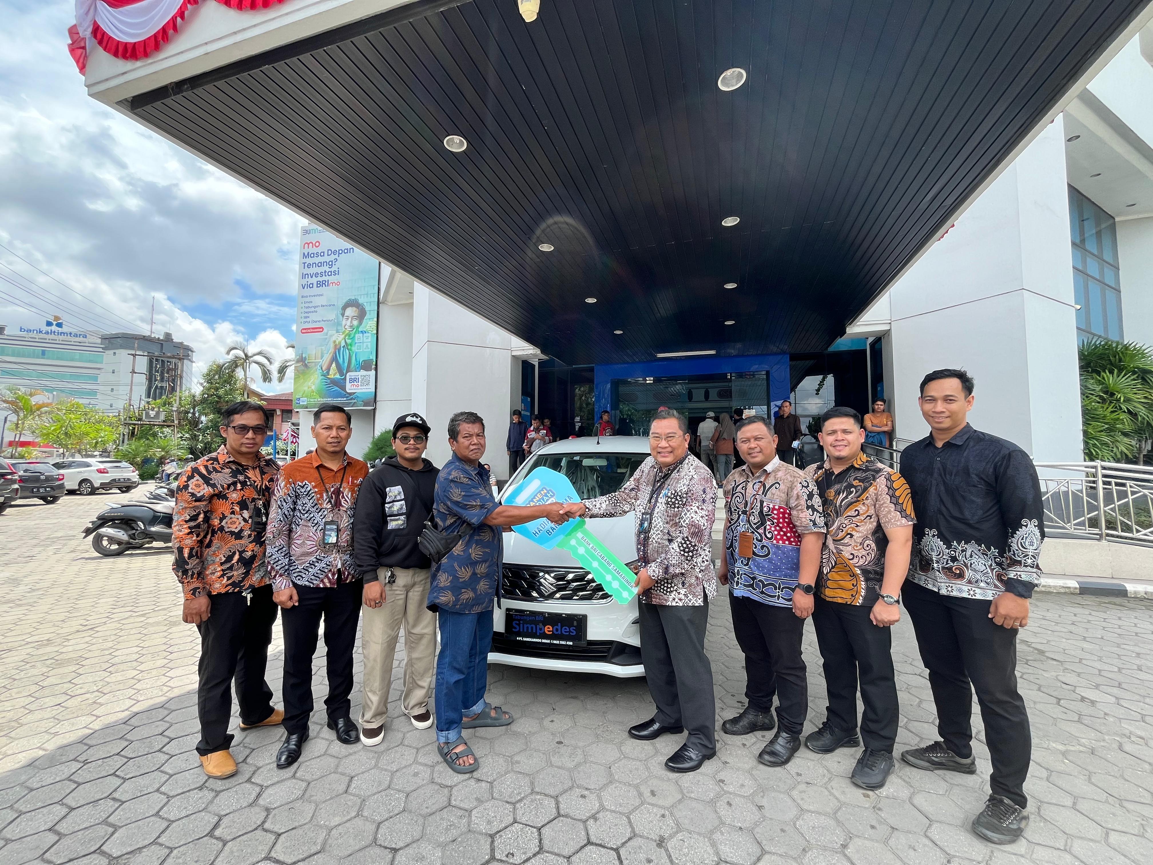 HADIAH UTAMA: Pimpinan BRI Cabang Samarinda Gajah Mada, Budhy Triadi (ketiga kanan) menyerahkan hadiah utama berupa 1 Suzuki Ertiga kepada Asrani warga kelurahan Loa Duri, Samarinda, Selasa (5/8).