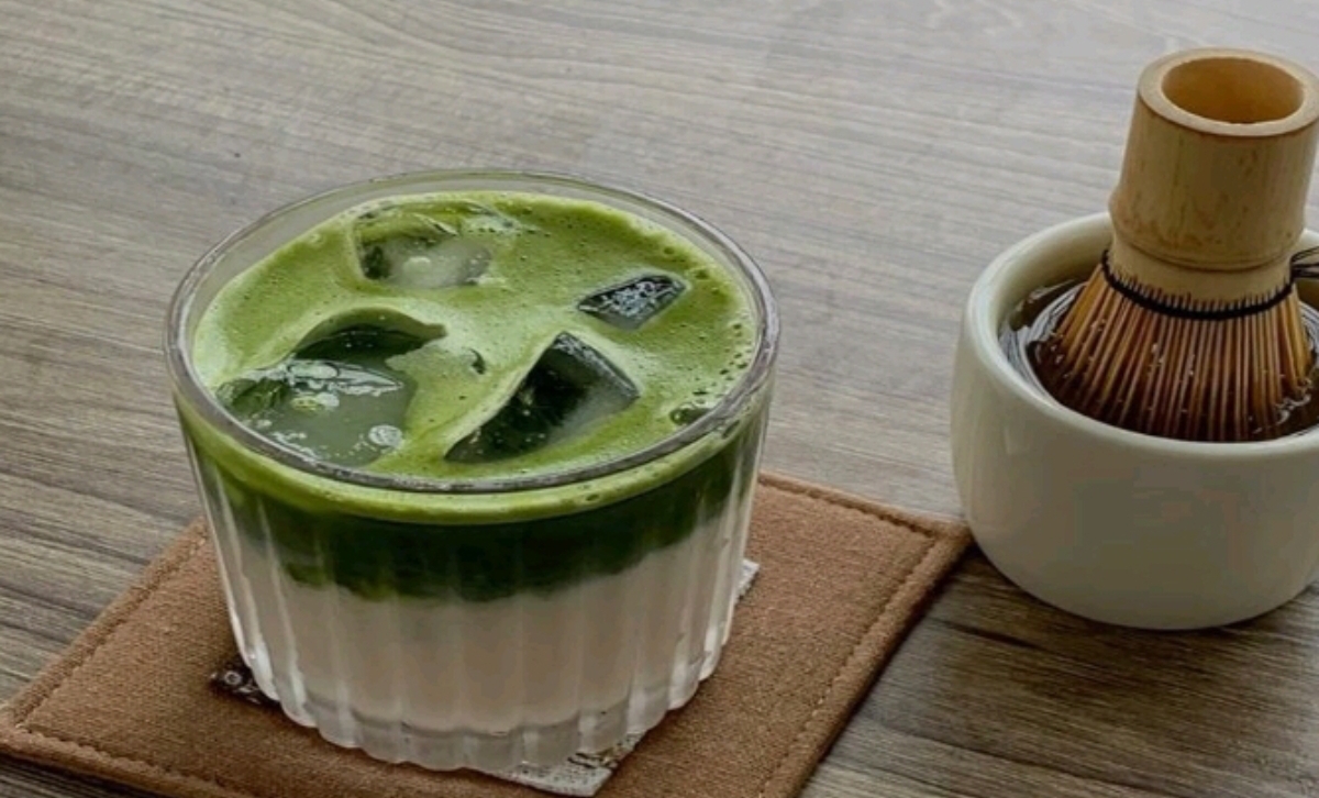 Segelas matcha latte dingin dengan lapisan hijau pekat yang menggoda, disajikan bersama chasen&mdash;alat tradisional Jepang untuk mengaduk matcha.  (Foto: Pinterest)