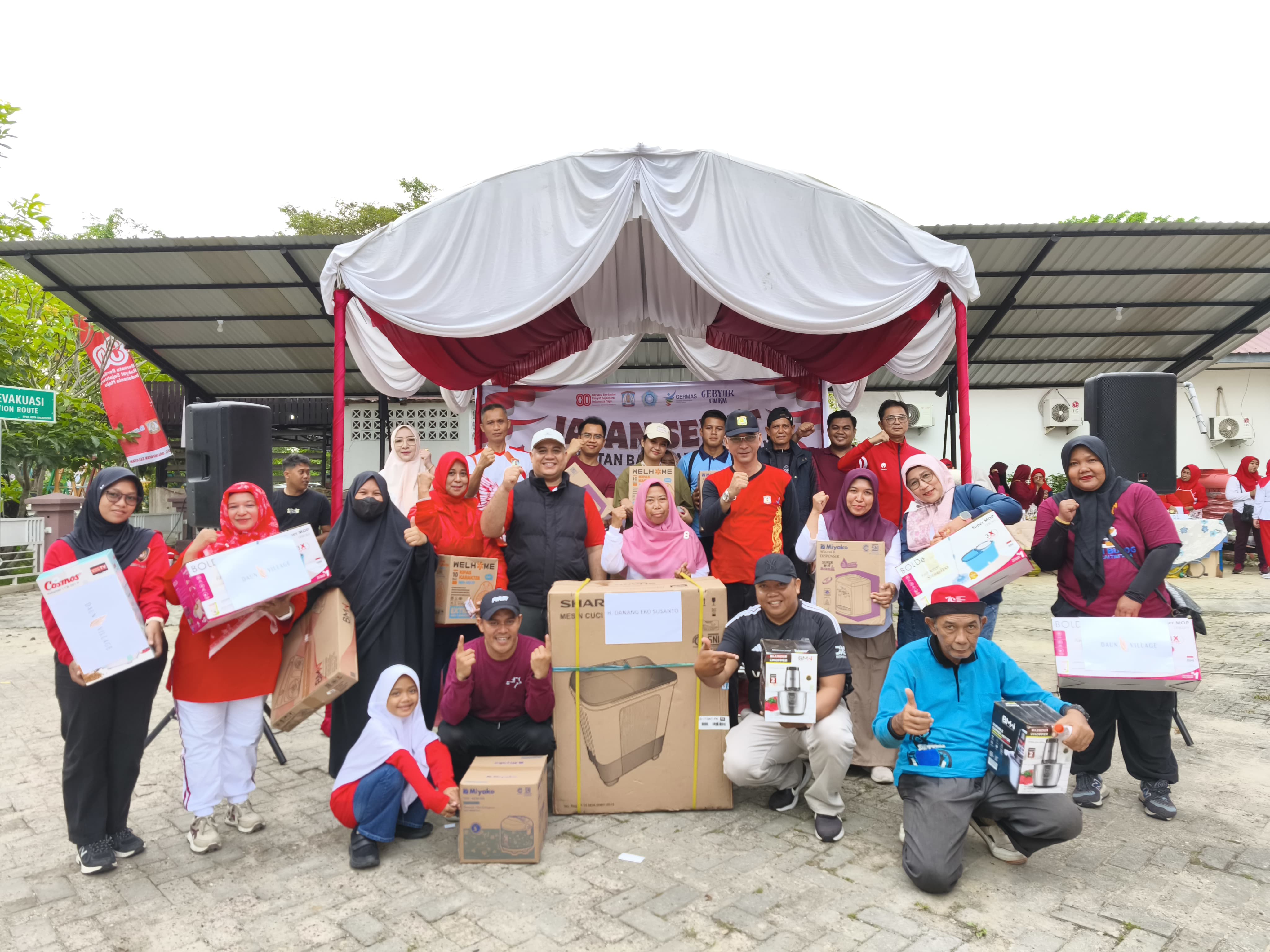 Camat, sekcam, dan para lurah bersama peserta jalan sehat yang beruntung mendapatkan hadiah.