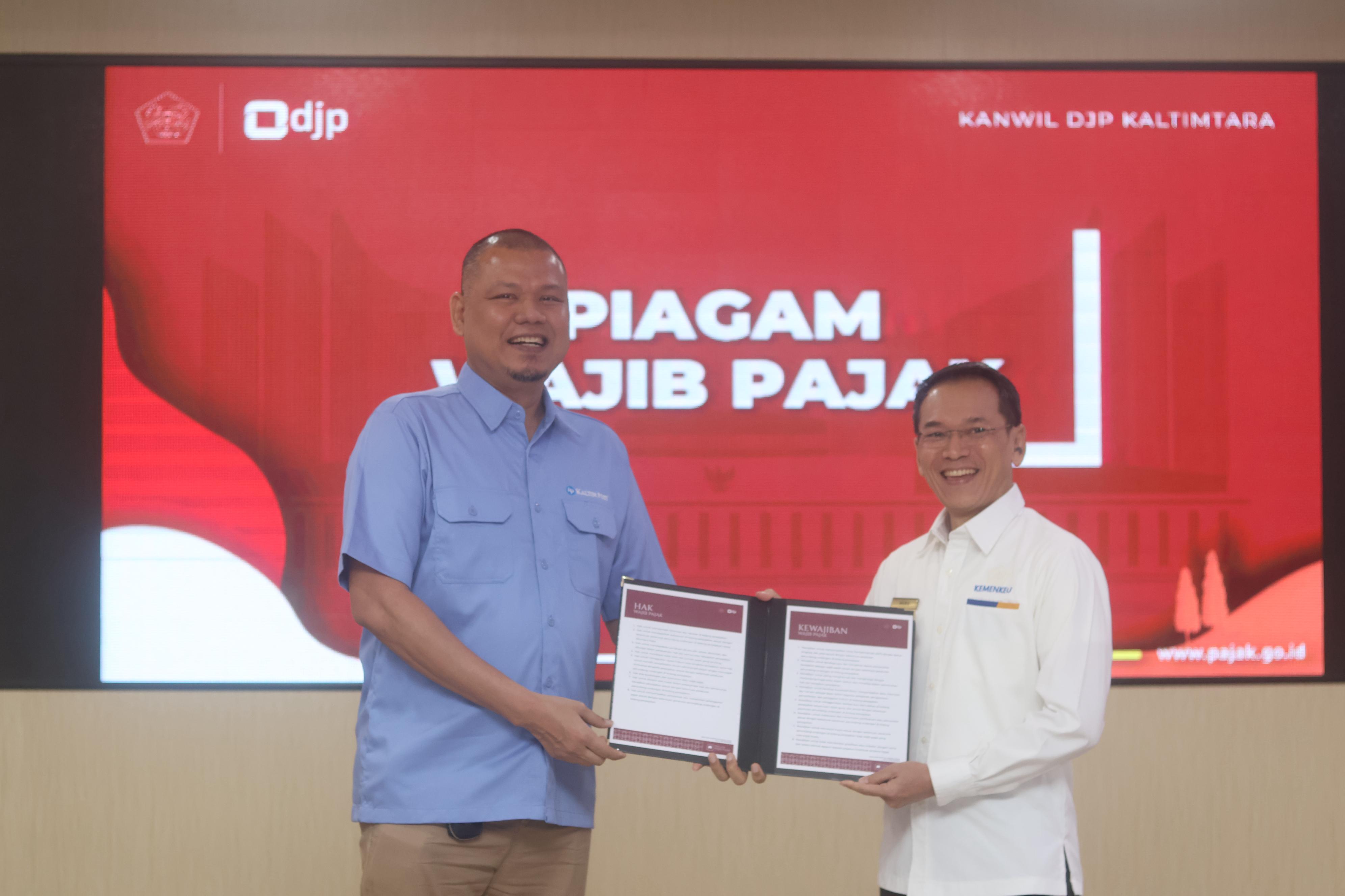 Direktur Kaltim Post Group Erwin Dede Nugroho  (kiri) menerima piagam wajib pajak  yang diberikan  Kepala Kantor Wilayah Direktorat Jenderal Pajak (DJP) Kalimantan Timur dan Utara Heru Narwanta.