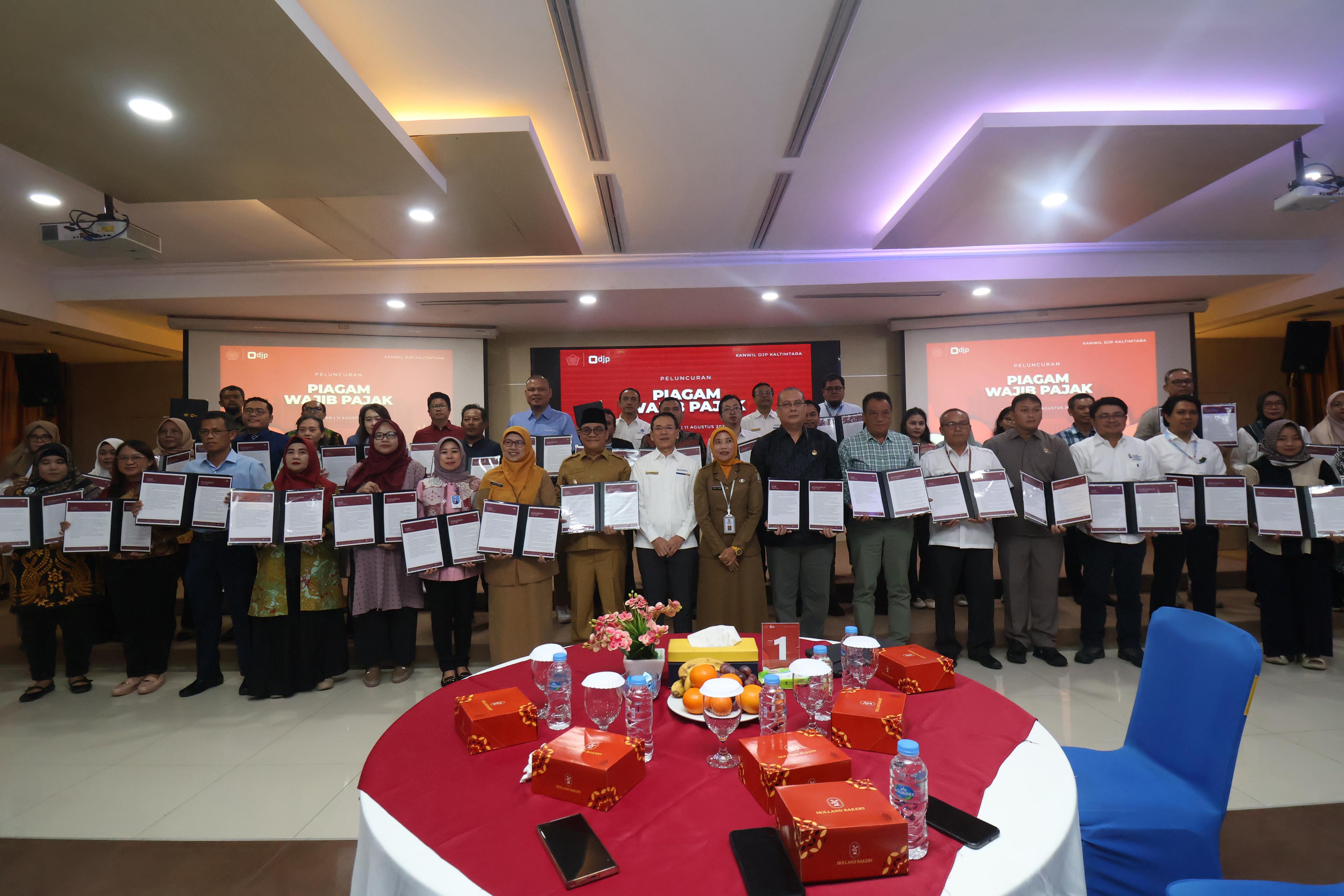 Para wajib pajak yang menerima piagam mengabadikan momen bersama di Aula Etam, Kantor Wilayah DJP Kalimantan Timur dan Utara, Balikpapan, Senin (11/8). (ANGGI PRADITHA/KP)