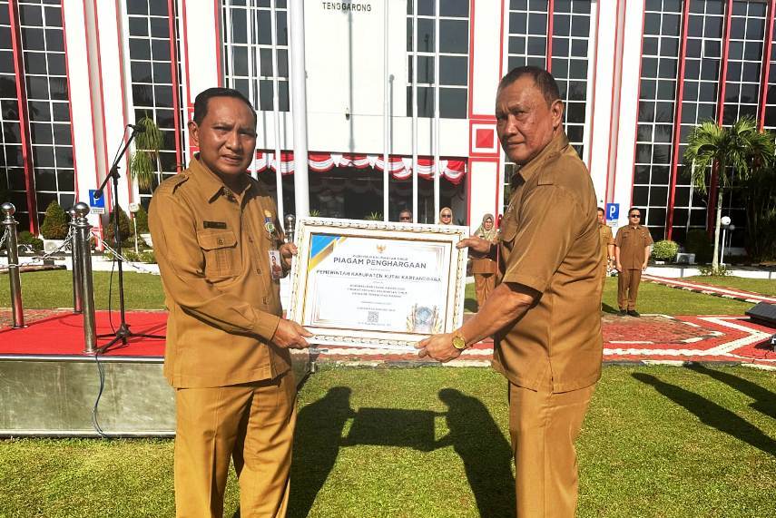 Plt Kepala Disnakertrans Kukar Muhammad Hatta menyerahkan penghargaan dari Gubernur Kaltim kepada Asisten II Ahyani Fadianur Diani (kiri).  &nbsp;
