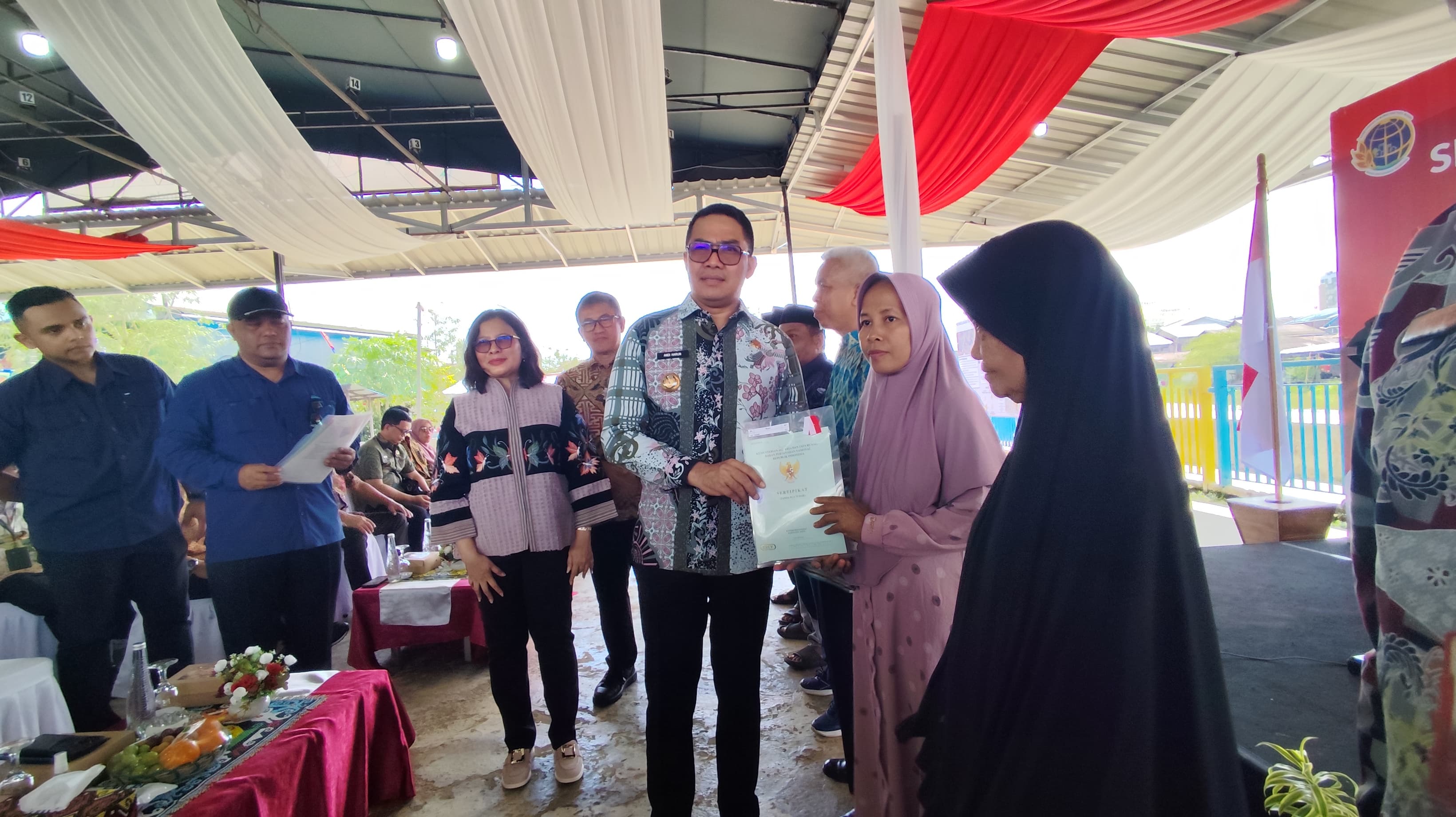 DUKUNGAN: Andi Harun (tengah) menyerahkan sertifikat tanah kepada warga dalam program Konsolidasi Tanah di kelurahan Sidodadi Kecamatan Samarinda Ulu, Kamis (14/8).