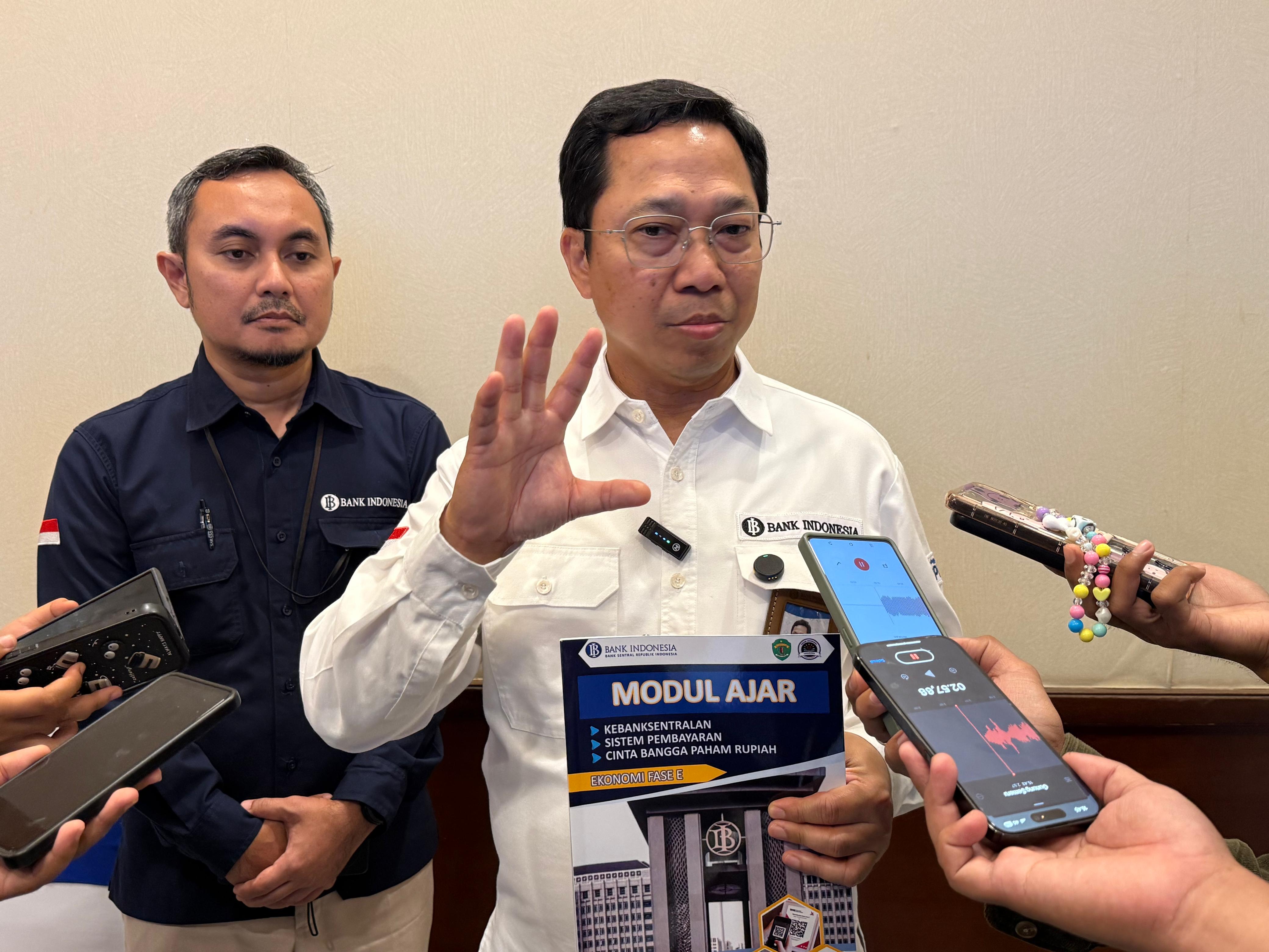 PEDOMAN: Kepala KPw BI Kaltim Budi Widihartanto menunjukkan modul ajar kepada para jurnalis.