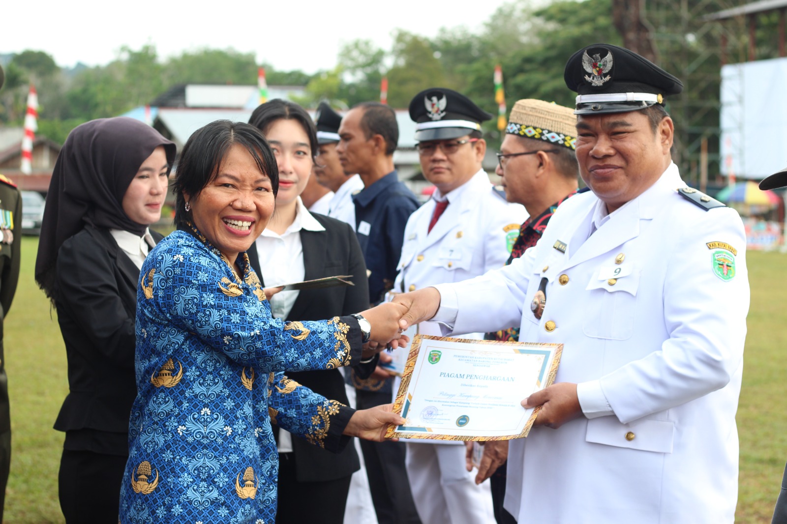 APRESIASI: Plt Camat Barong Tongkok, Bona Ednawati (kiri) menyerahkan penghargaan. (IST)