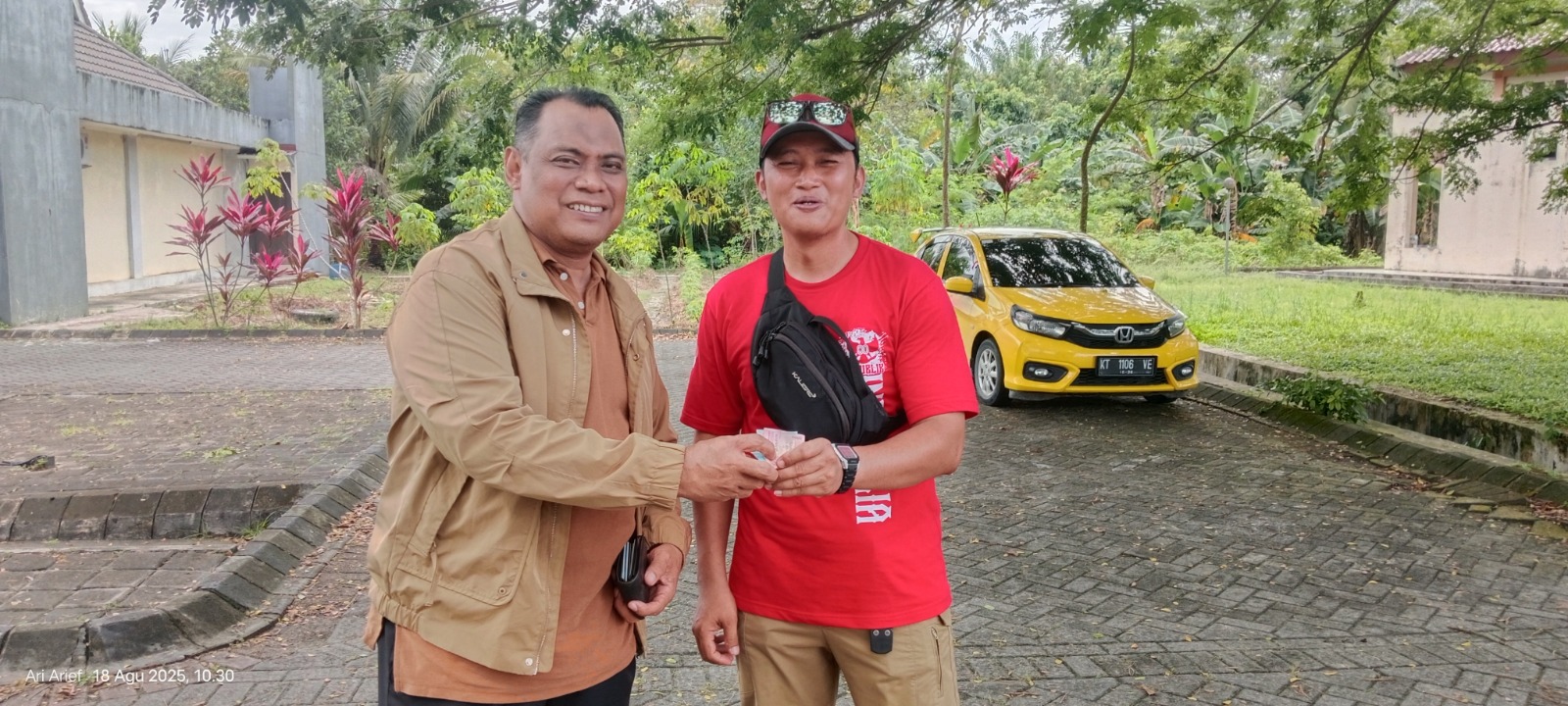 TURUN TANGAN: Taufik (kiri) saat memberikan sumbangan berupa uang yang diserahkan melalui Ketua RT 07, Nenang, Agus, untuk membeli cat biaya pembersihan monumen. (IST)