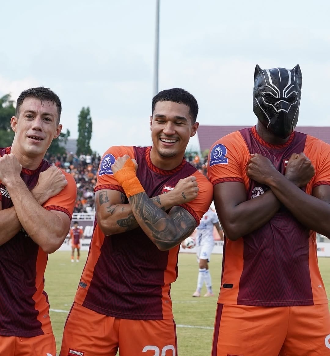 Joel Vinicius mengenakan topeng Black Panther sembari memberikan gesture Wakanda Forever.