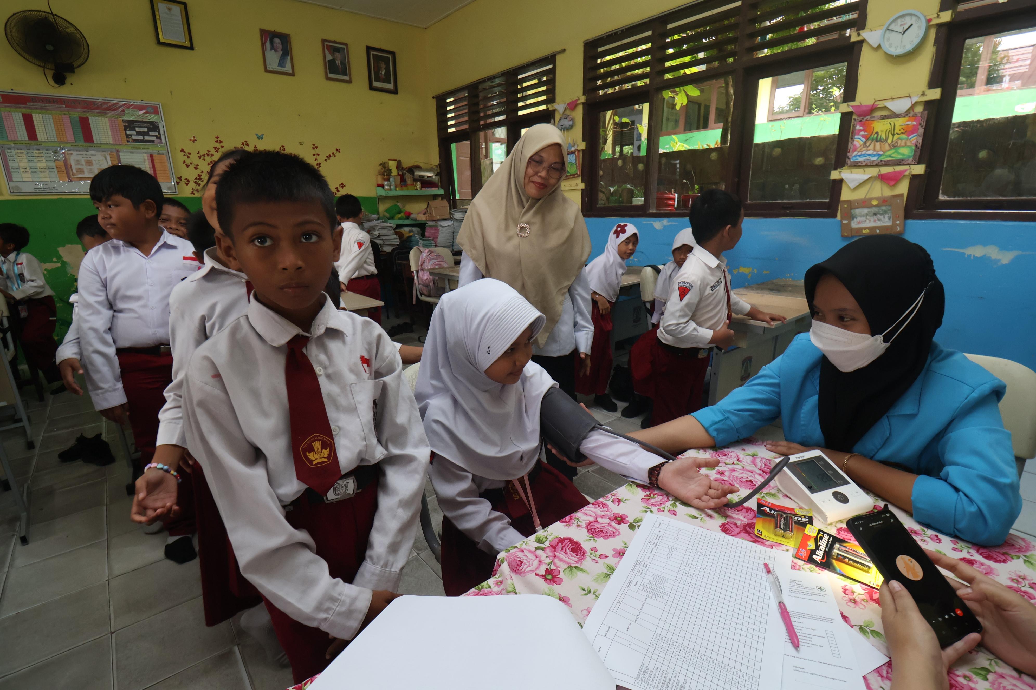 PEMERIKSAAN: Program cek kesehatan gratis (CKG) juga sudah menyasar siswa. Seperti petugas Puskesmas Batu Ampar turun ke SD 022 Balikpapan Utara.