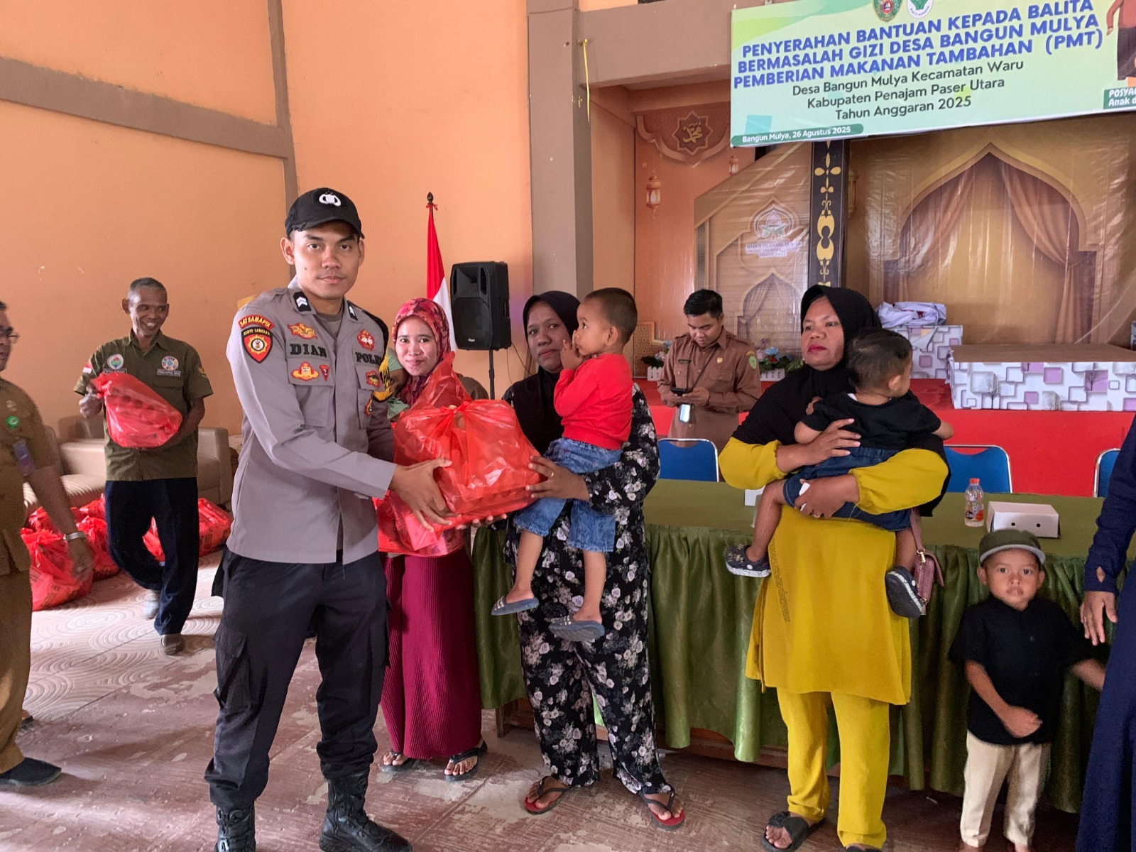 Personel kepolisian Polres PPU turut membantu menyerahkan bantuan kepada balita bermasalah gizi di Waru, PPU.