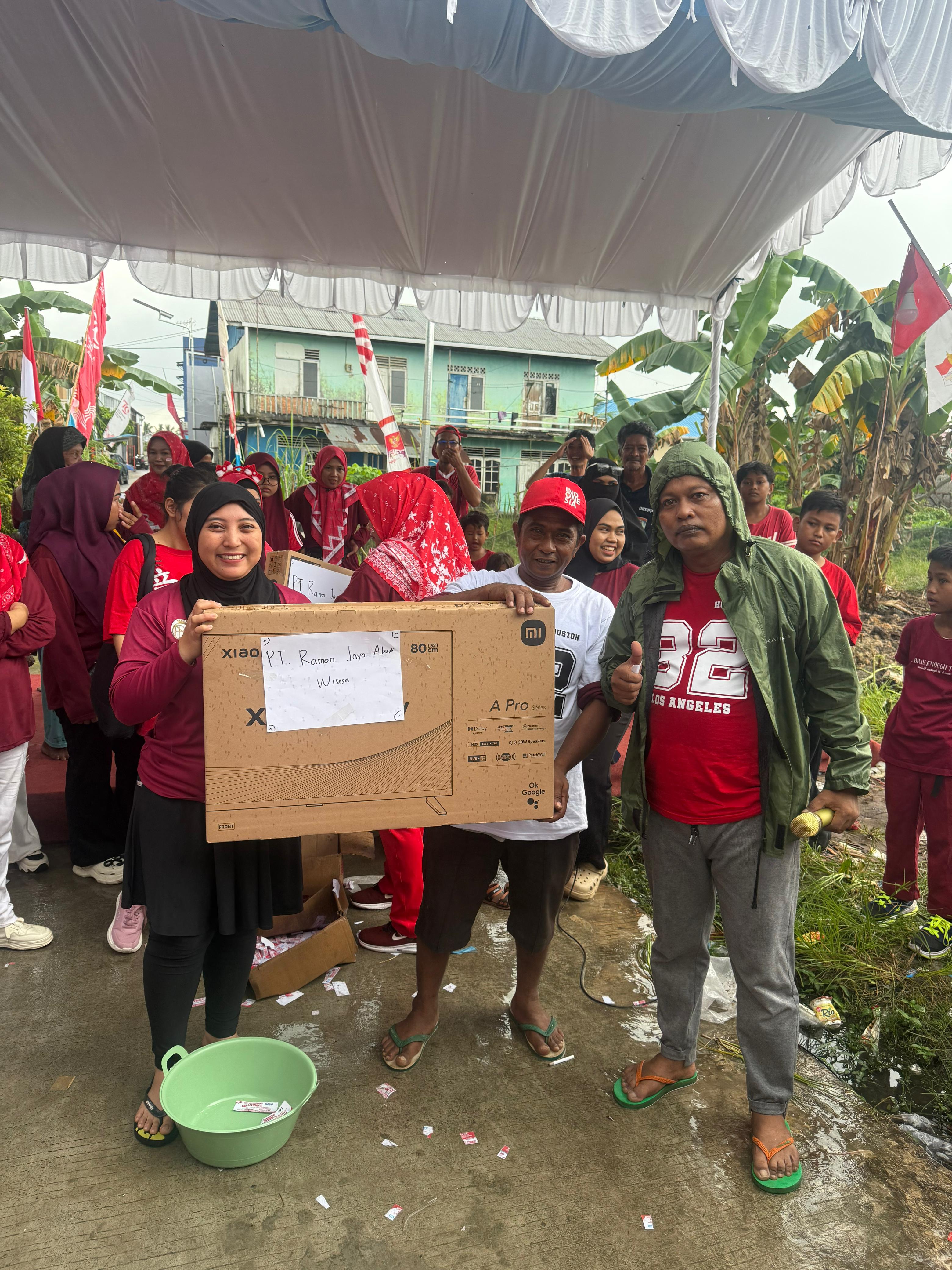 Ketua RT 32 Manggar Andi Aspar menyerahkan hadiah utama TV LED kepada peserta jalan sehat yang beruntung.