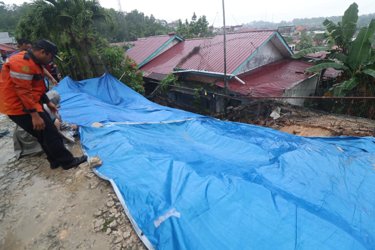 Petugas melakukan antisipasi dengan memasang terpal jika terjadi longsor susulan. (FOTO ANGGI PRADITHA/KP