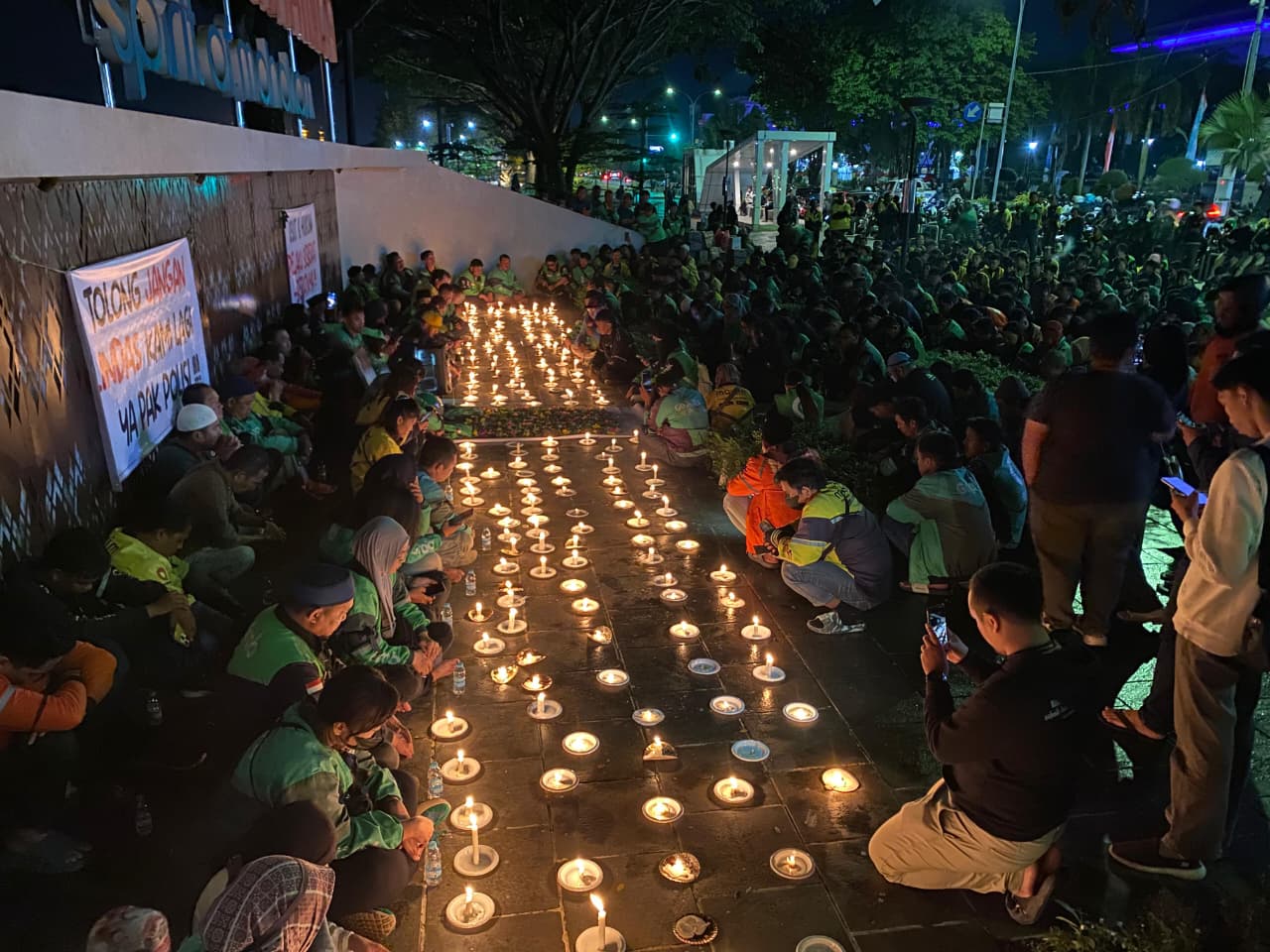 Cahaya lilin menyala di Teras Samarinda, Minggu (31/8) malam. Ratusan ojol berkumpul, berdoa, dan merenung. (FOTO EKO PRALISTIO/KP)