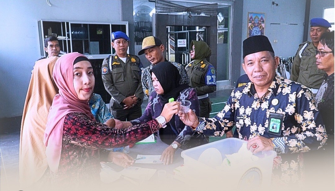 MENDADAK: Kepala Kantor Kemenag PPU, Muhammad Syahrir (kanan) saat menerima alat semacam urinoir pada tes urine mendadak yang diselenggarakan oleh BNK PPU.